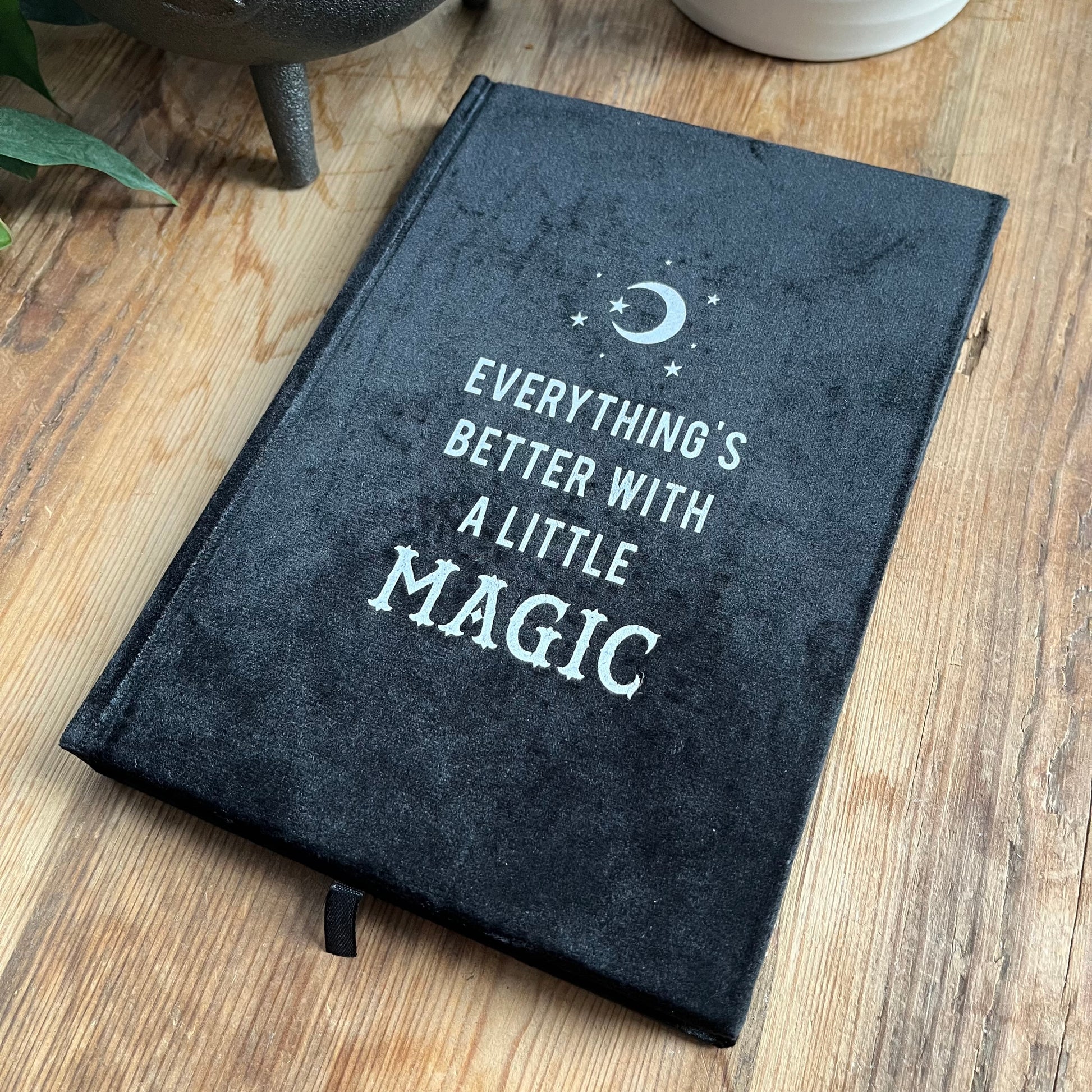 Black velvet notebook. Front cover has moon and stars design and the words 'everything's better with a little magic'