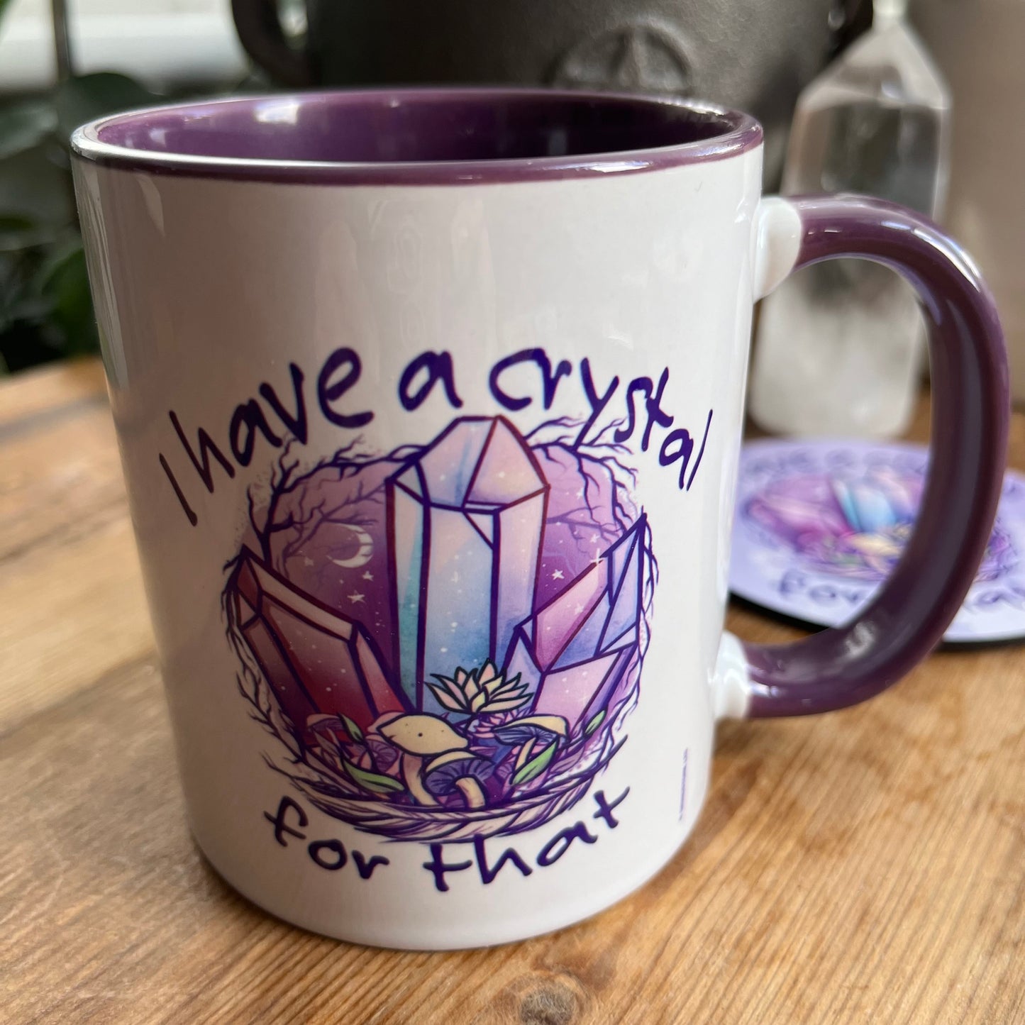 A white and purple mug  featuring an illustration of crystals and the words 'I have a crystal for that on both sides' 