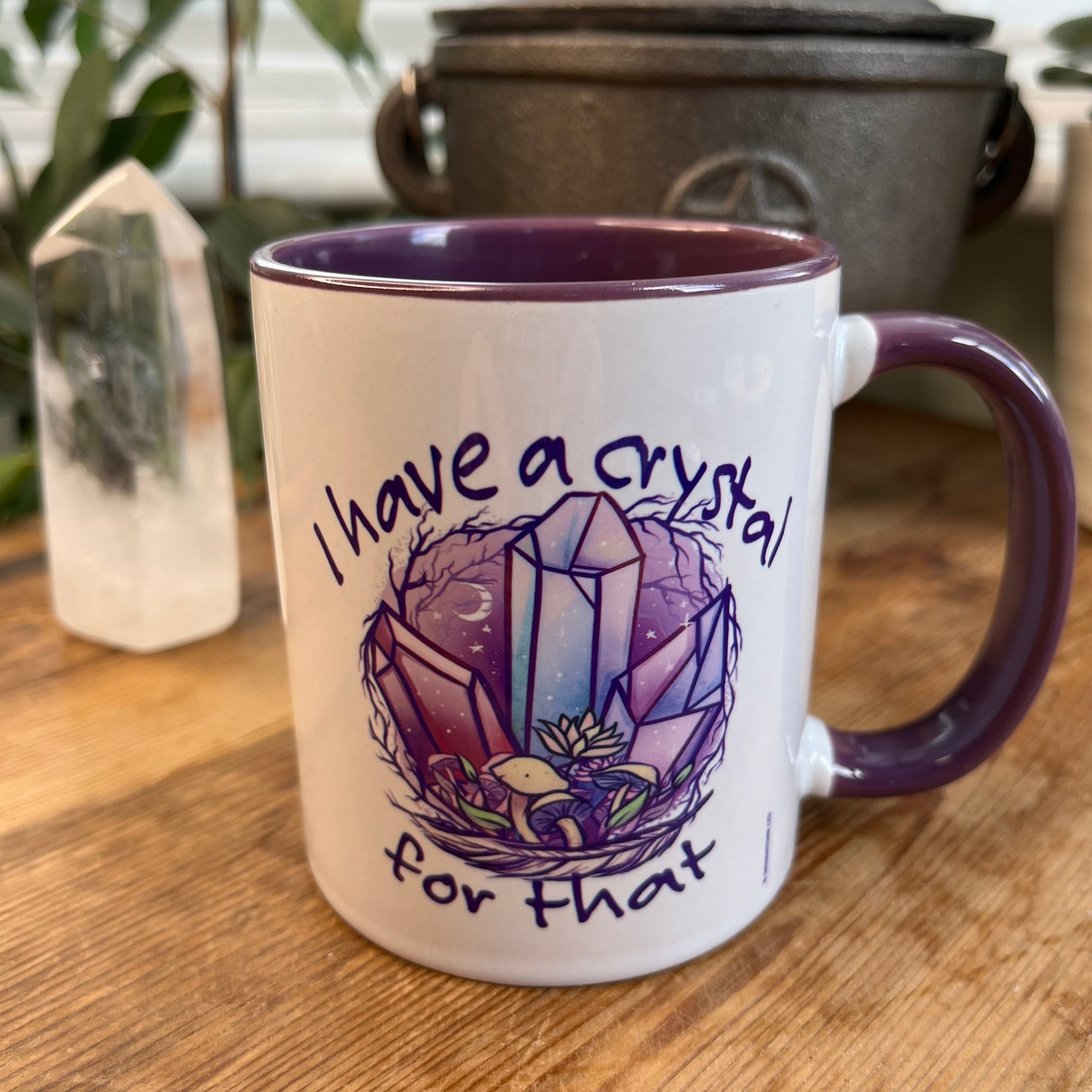 A white and purple mug  featuring an illustration of crystals and the words 'I have a crystal for that on both sides' 