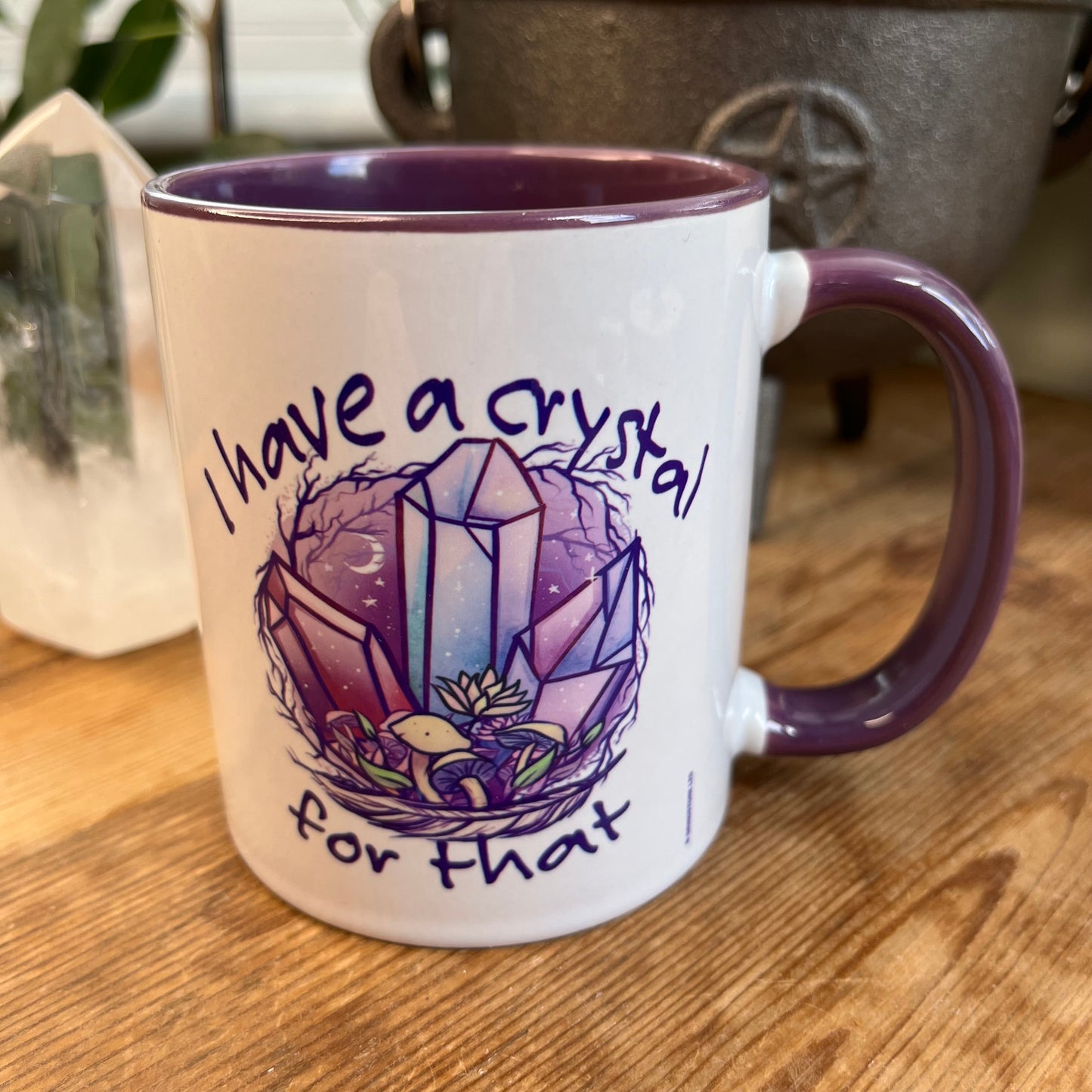 A white and purple mug  featuring an illustration of crystals and the words ' i have a crystal for that on both sides' 