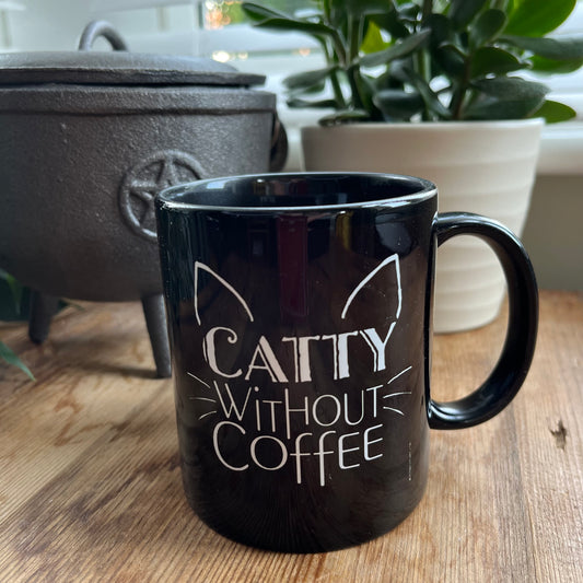 Black mug with the words 'caty without coffee' in white and an illustration of cats ears and whiskers 