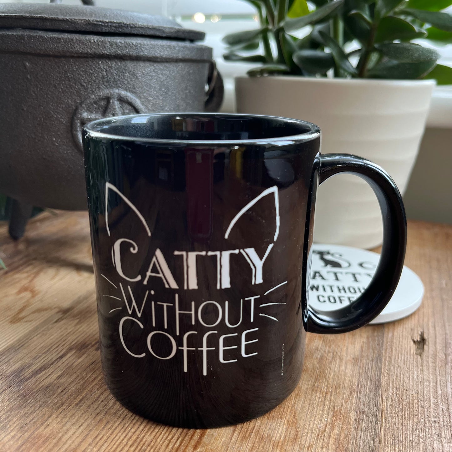 Black mug with the words 'caty without coffee' in white and an illustration of cats ears and whiskers 