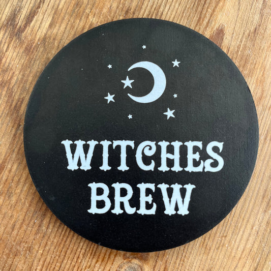 Black Coaster with the words 'witches brew' in white cursive text 