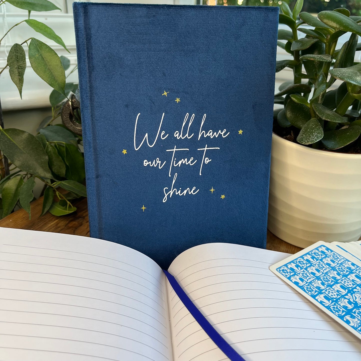 Blue velvet A5 notebook features words 'we all have our time to shine' A second notebook shows the lined pages and blue ribbon  page divided inside the notebook 