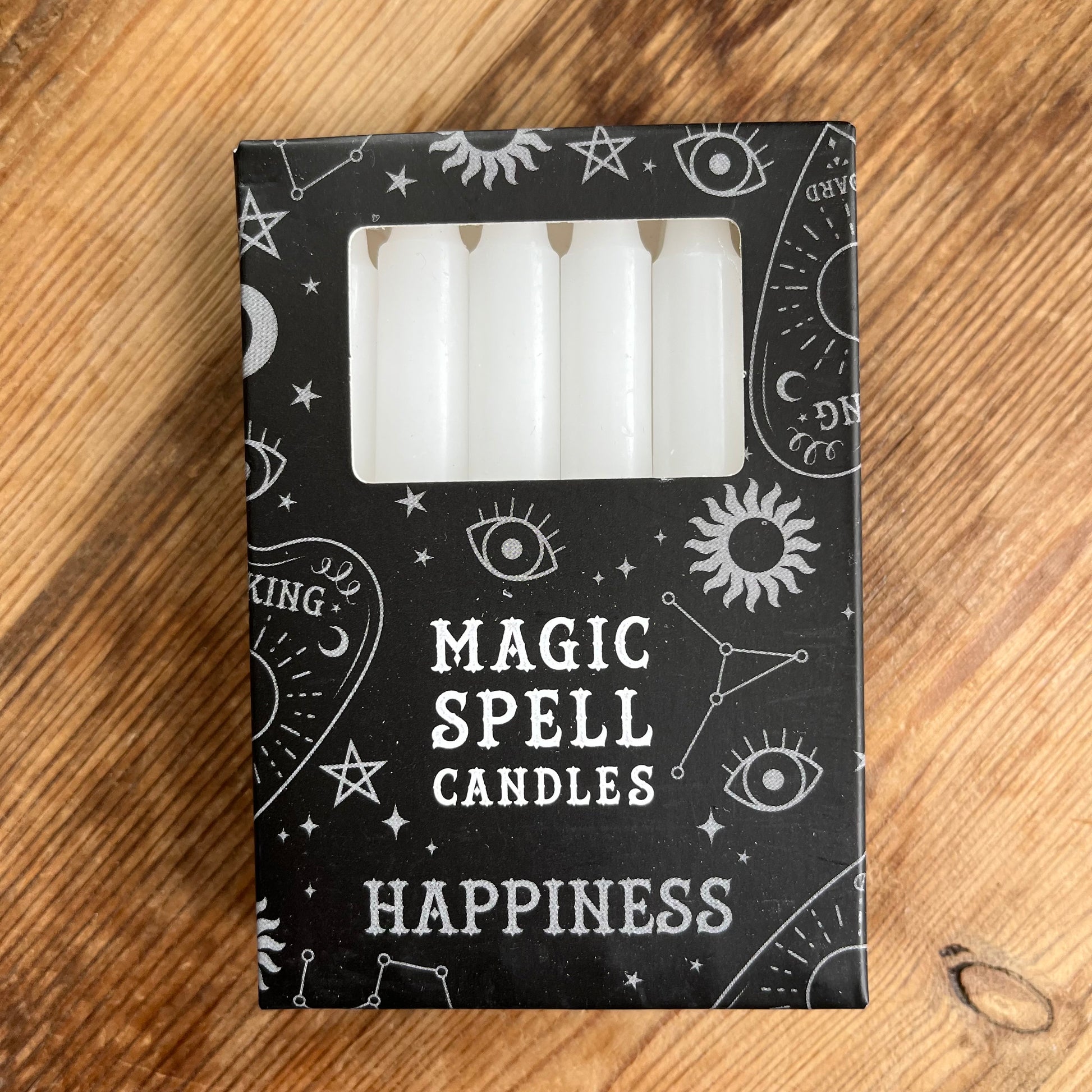 Black box containing 12 white spell candles the box reads magic spell candles for happiness 