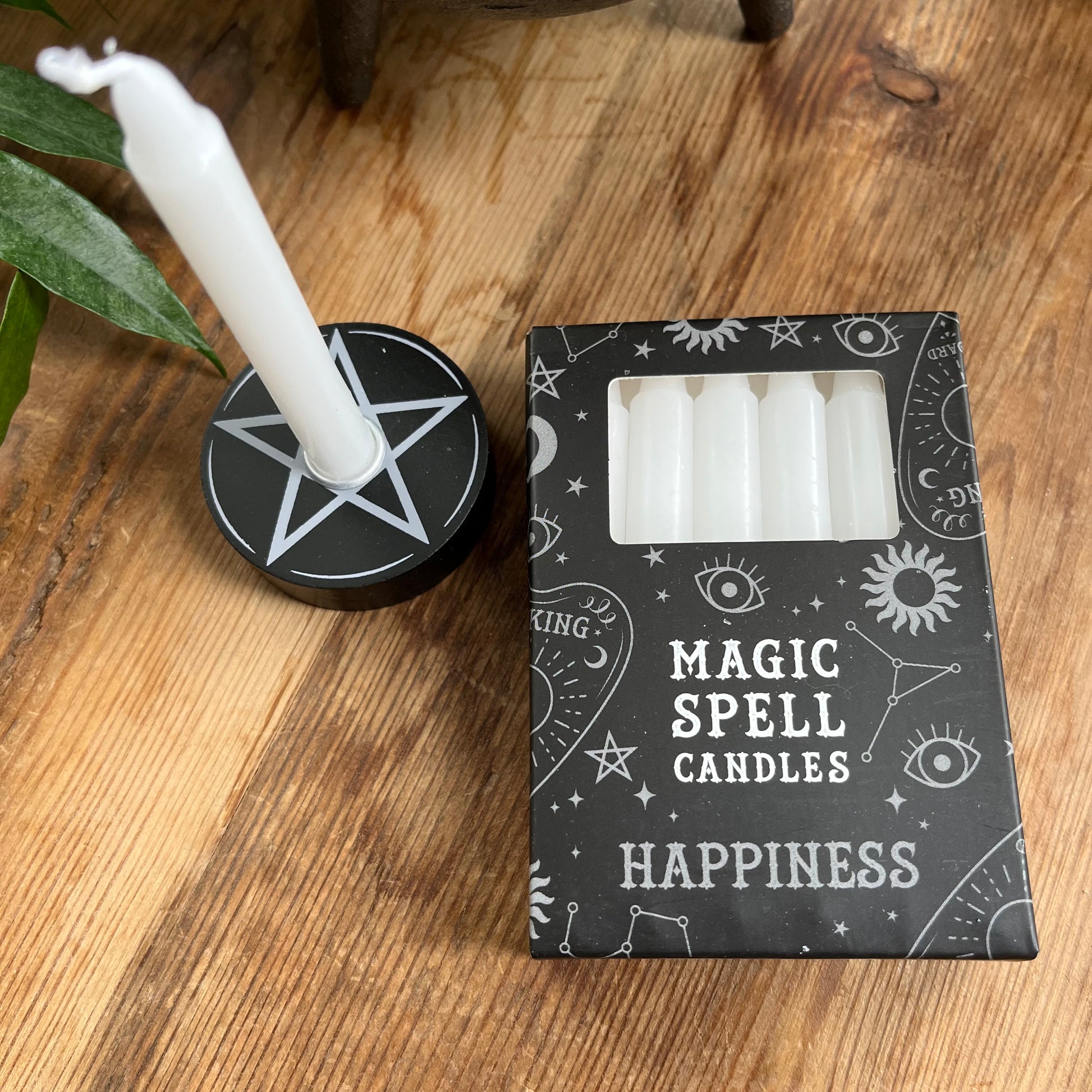 Black box containing 12 white spell candles the box reads magic spell candles for happiness 