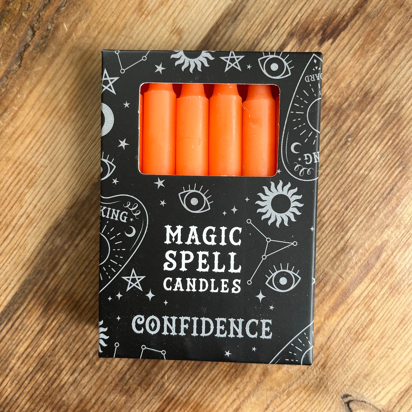 Black box containing 12 orange spell candles the box read magic spell candles for confidence