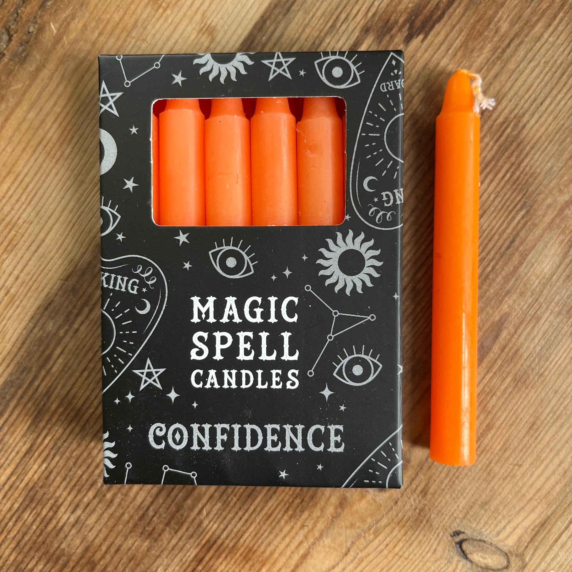 Black box containing 12 orange spell candles the box read magic spell candles for confidence