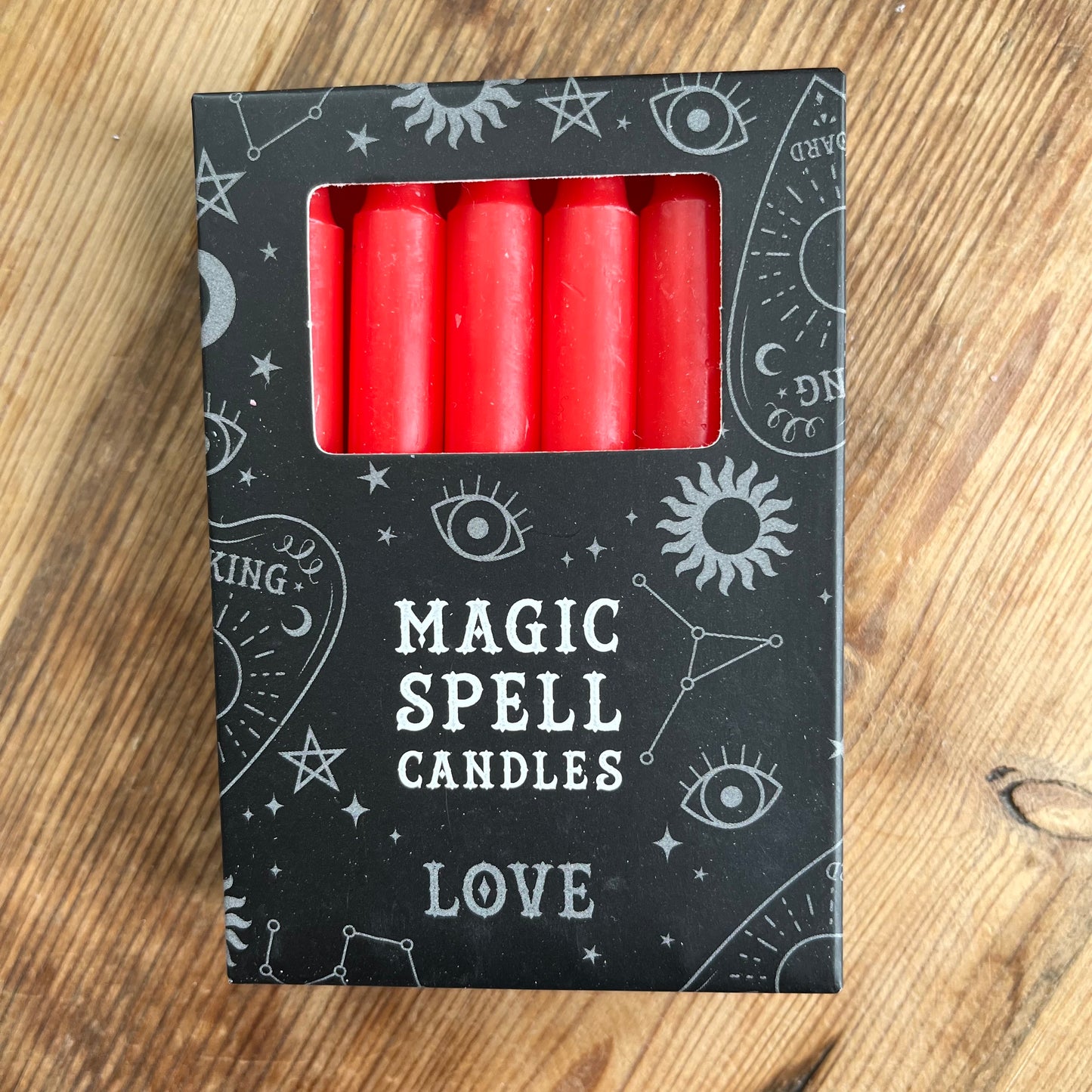 Black box containing 12 red spell candles the box reads magic spell candles for Love