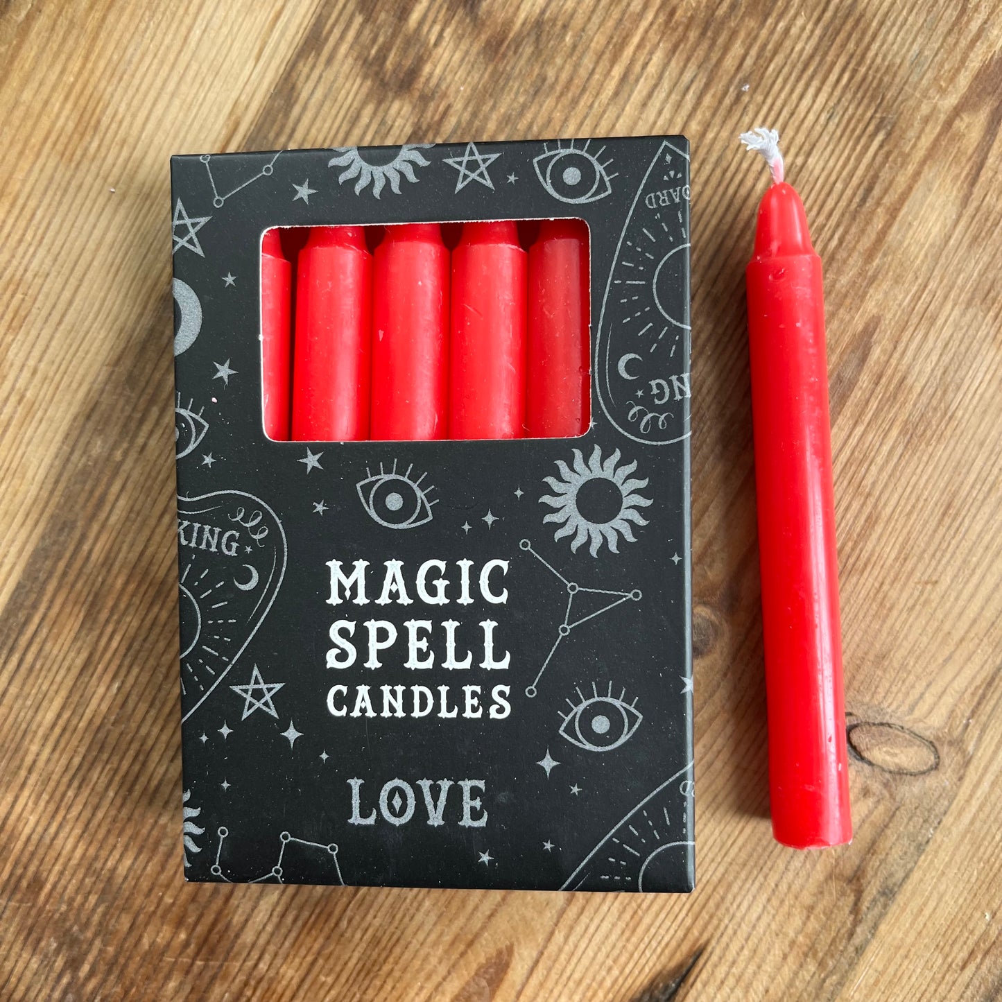 Black box containing 12 red spell candles the box reads magic spell candles for Love