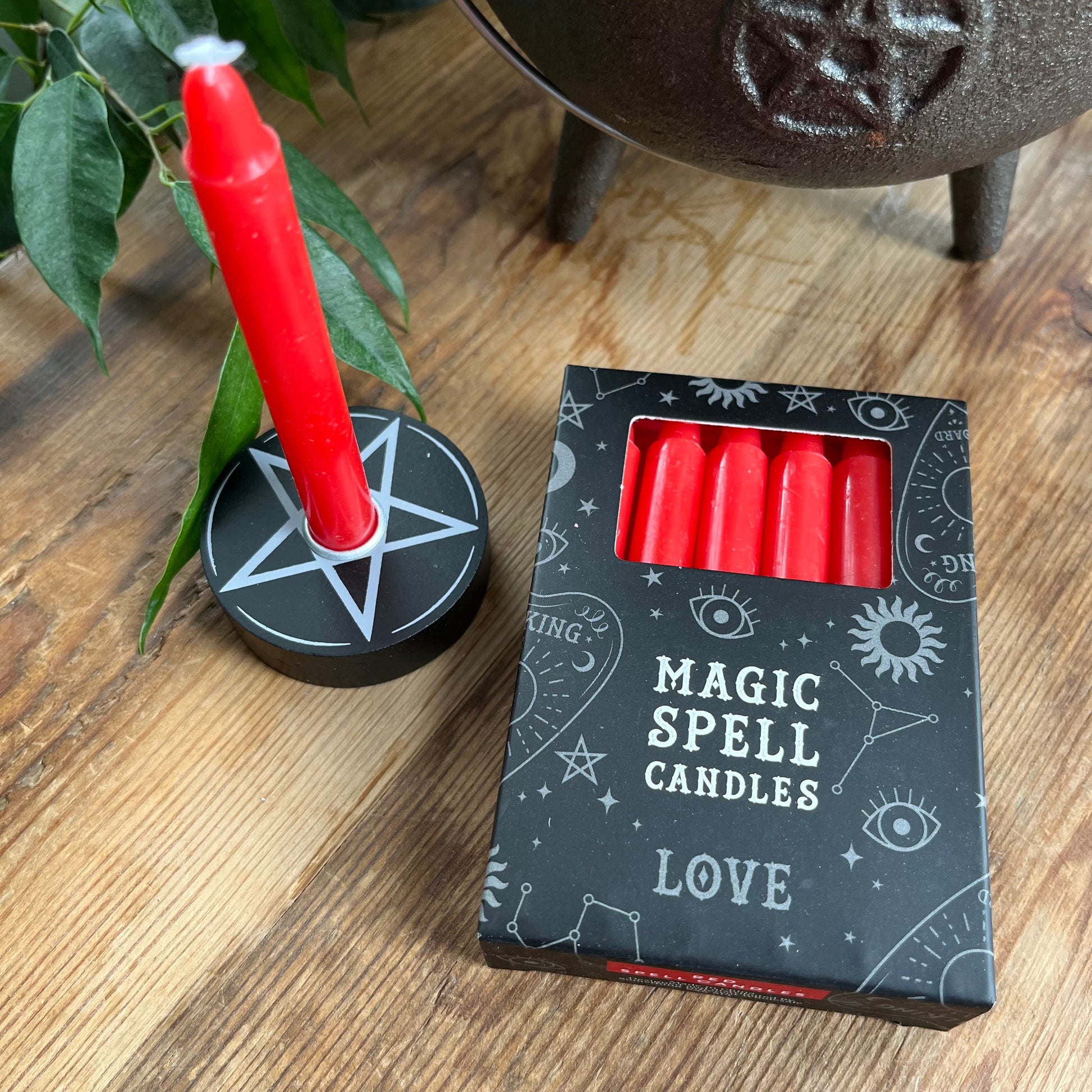 Black box containing 12 red spell candles the box reads magic spell candles for Love