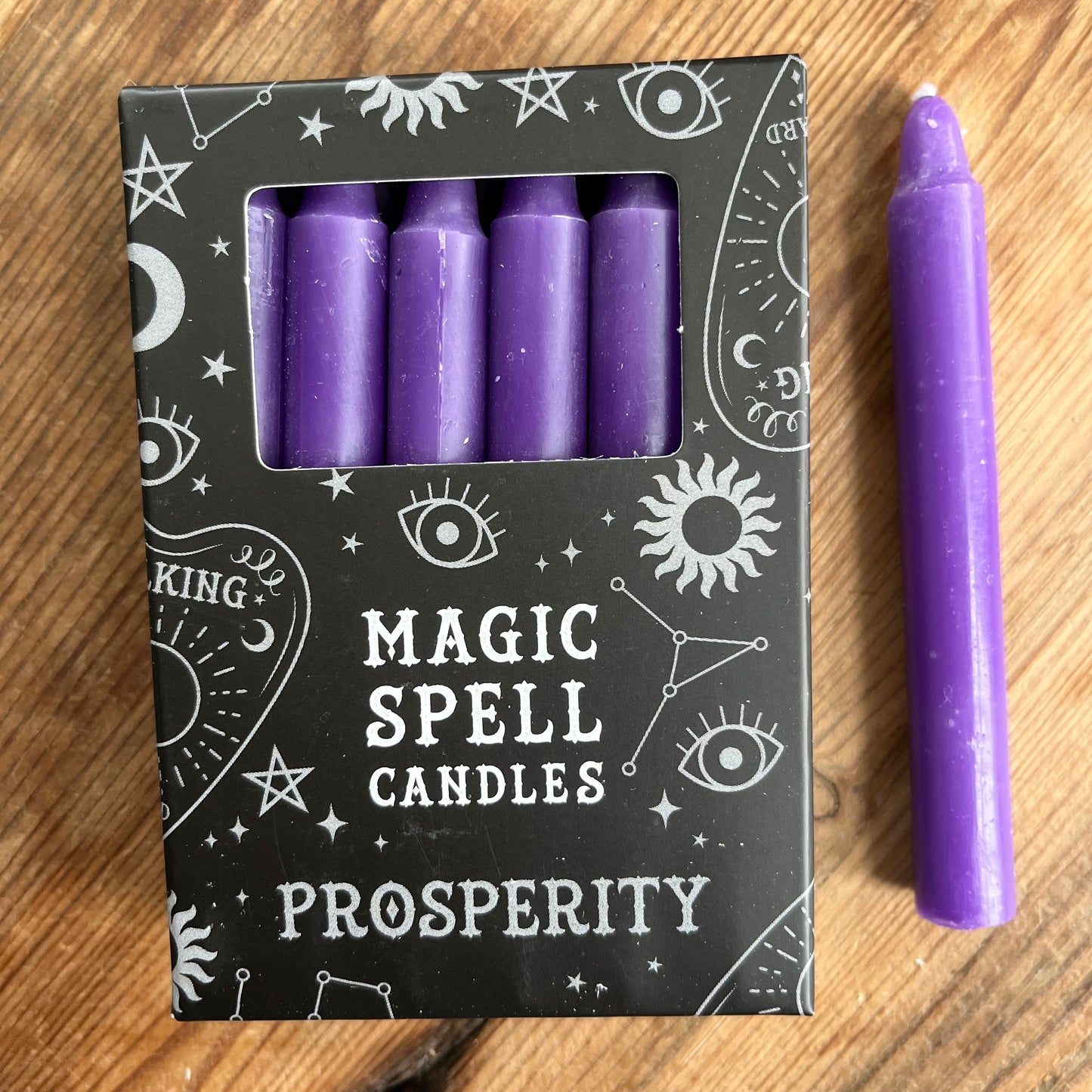 Black box containing 12 purple spell candles the box reads magic spell candles for prosperity