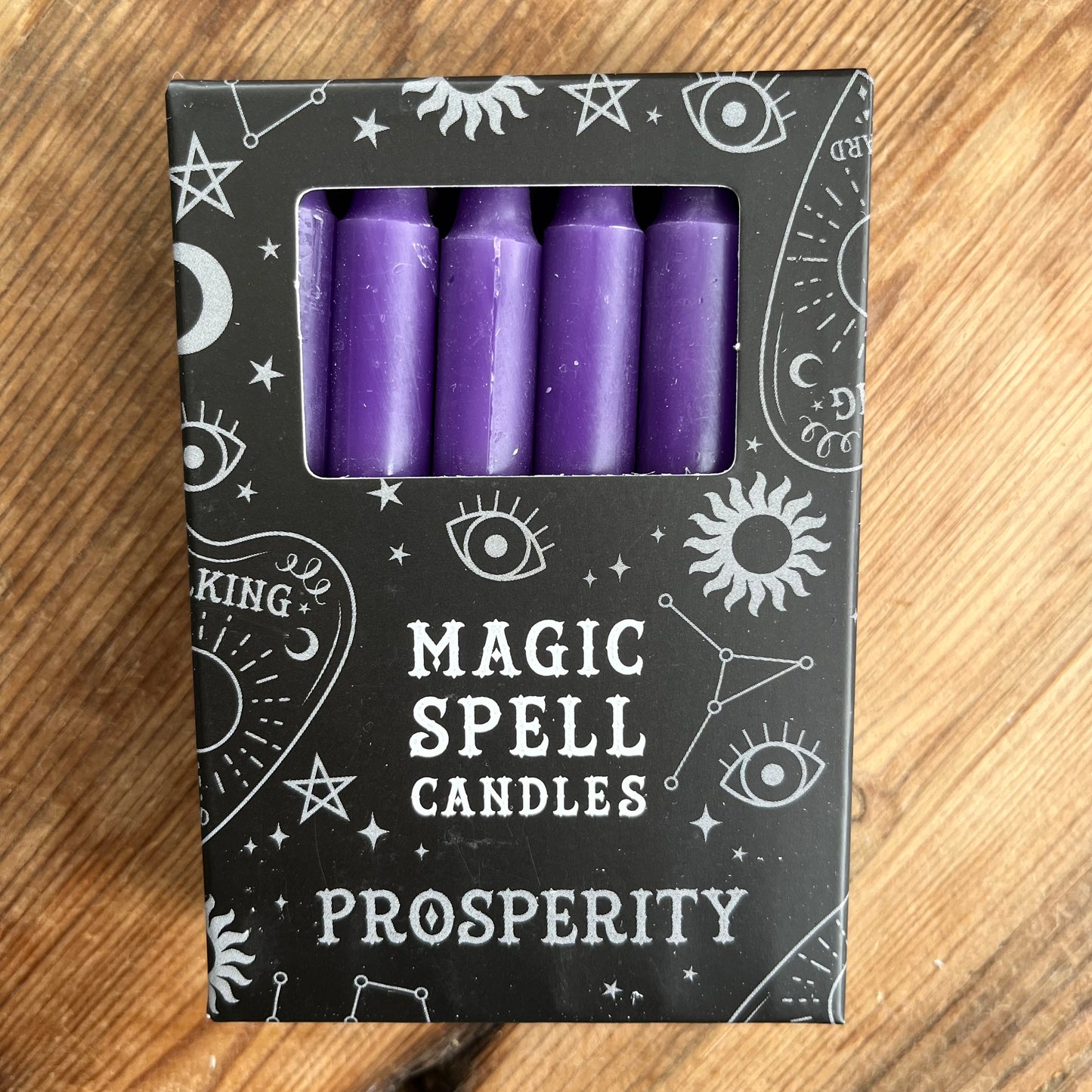 Black box containing 12 purple spell candles the box reads magic spell candles for prosperity