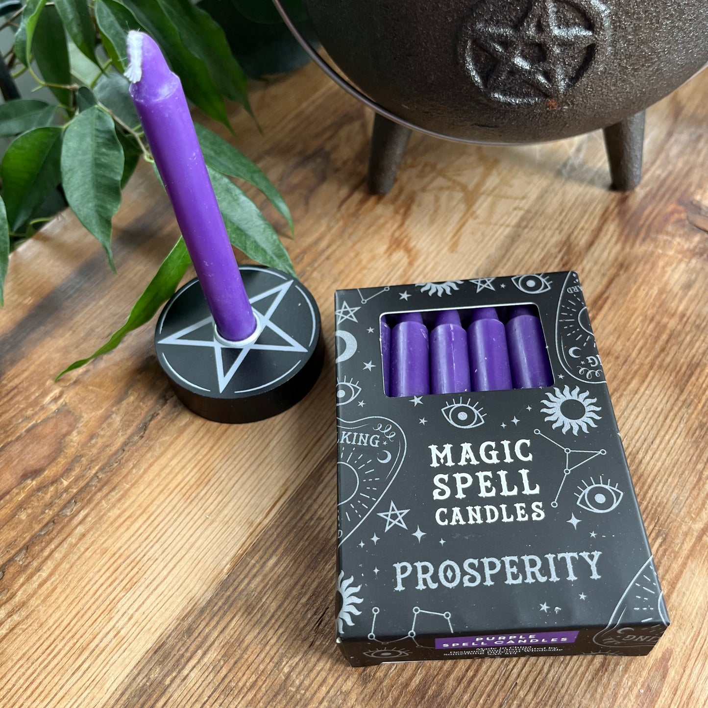 Black box containing 12 purple spell candles the box reads magic spell candles for prosperity