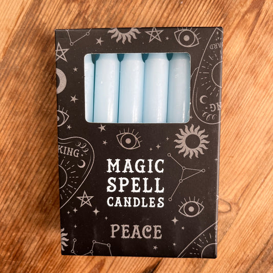 Black box contining 12 light blue spell candles the box reads magic spell candles for peace