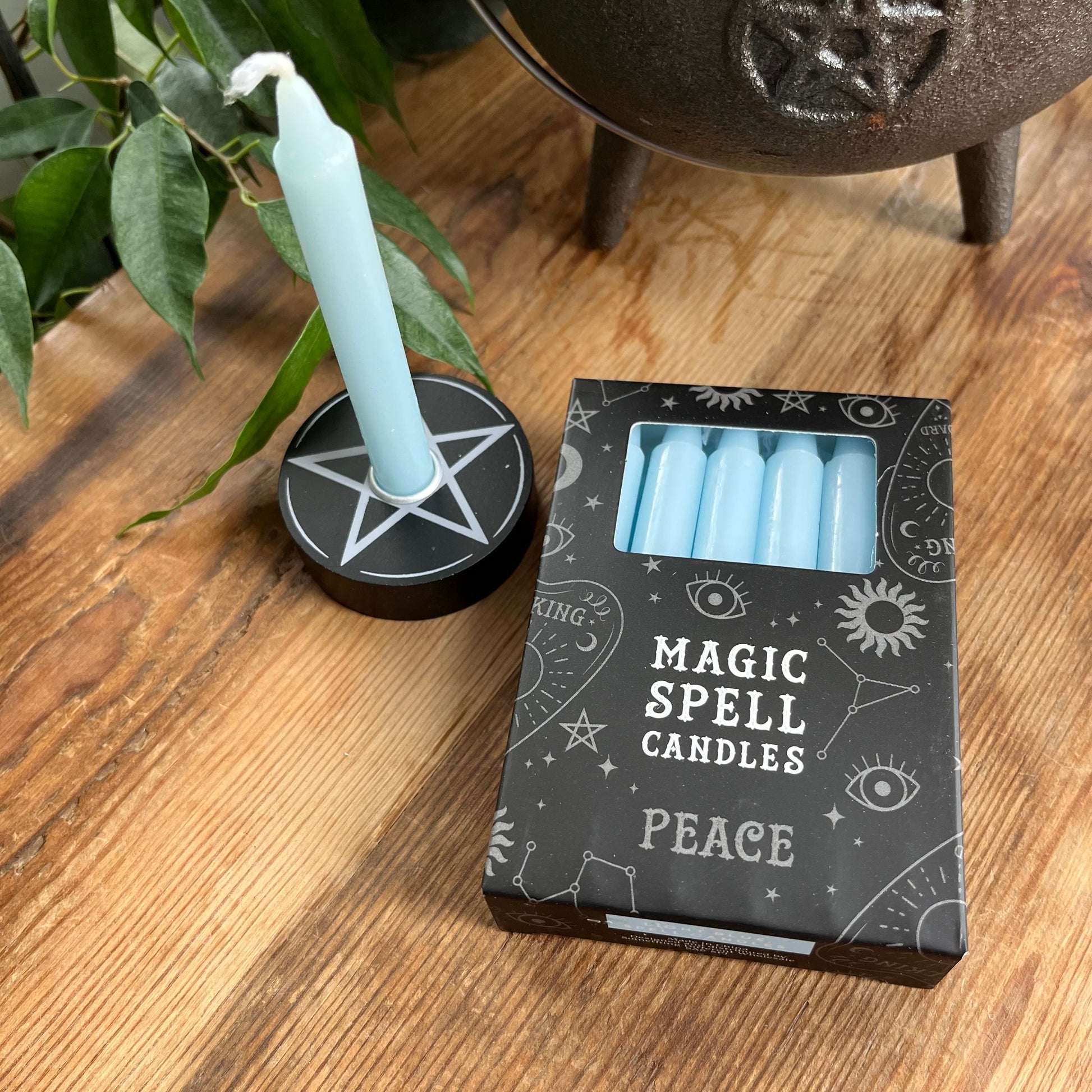 Black box contining 12 light blue spell candles the box reads magic spell candles for peace