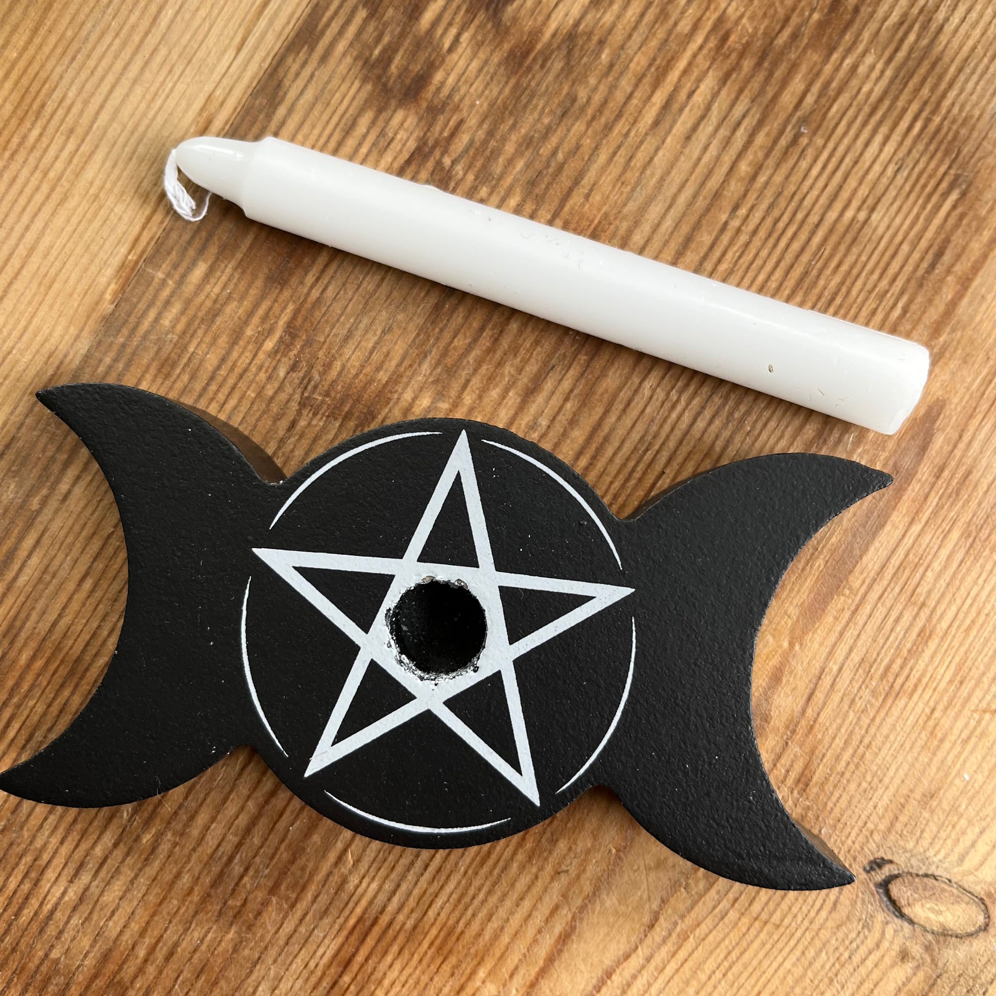 Black wooden spell candle holder in the shape of a triple moon with a Pentagram in white on its surface 