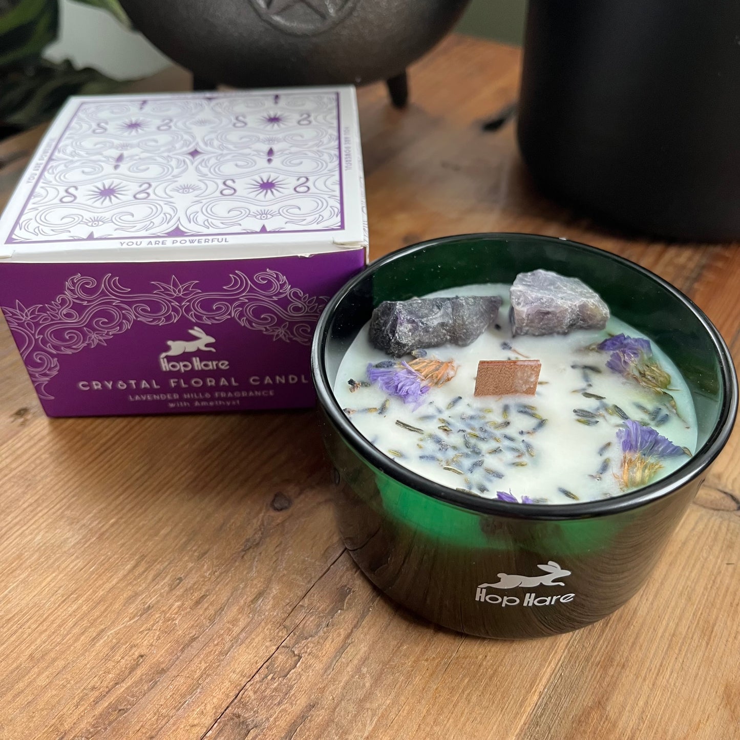 The hop hare moon candle can be seen next to it's purple and white decorated cardbard presentation box 