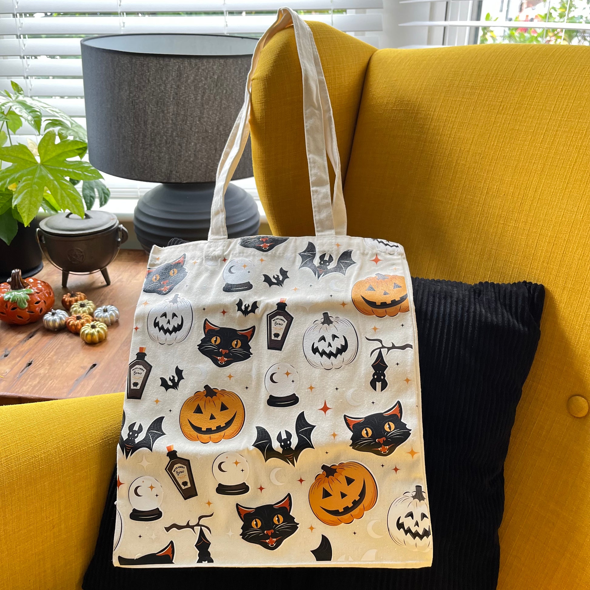 Tote bag with Halloween design on a yellow couch