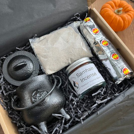 Witchcraft supply kit with black cauldron, Samhain incense, and other items in a box.