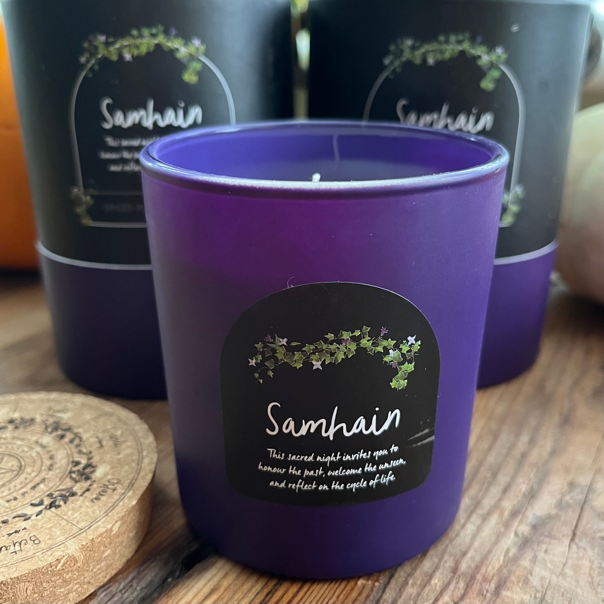 Purple candle with 'Samhain' label on a wooden surface