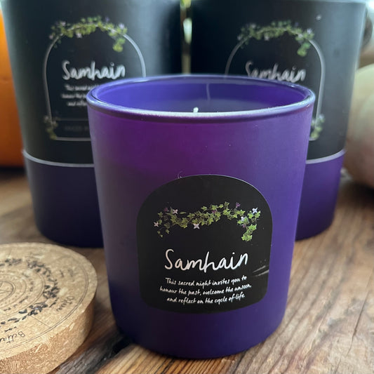 Purple candle with 'Samhain' label on a wooden surface