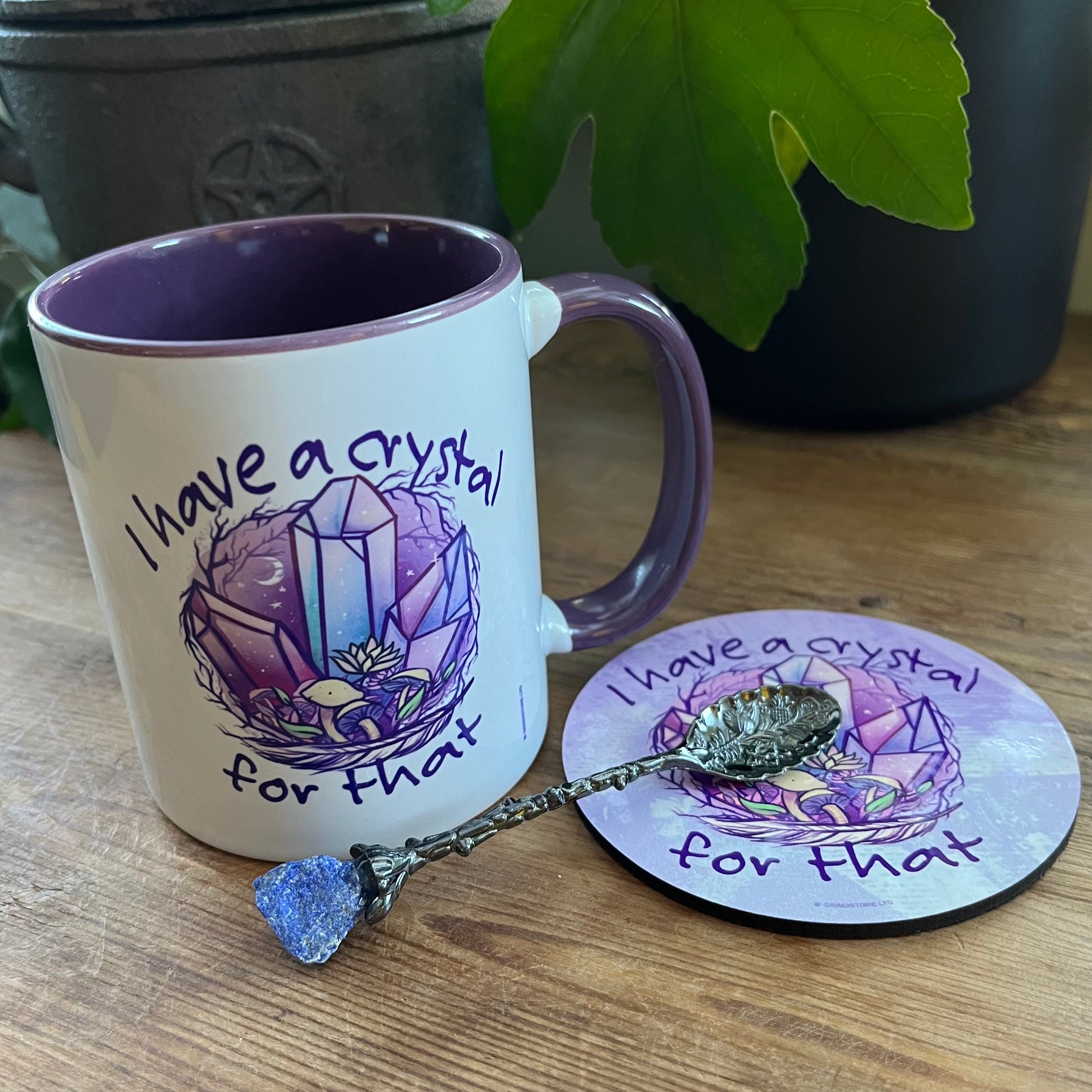 Mug, coaster, and spoon with crystal design on a wooden surface