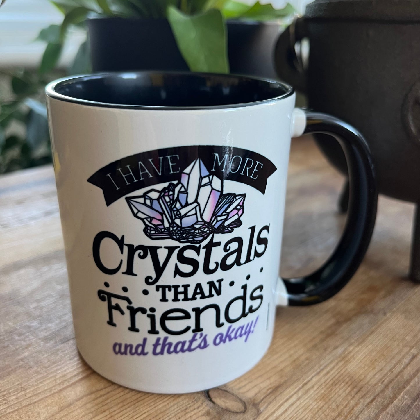 Mug with crystal-themed design and text on a wooden surface