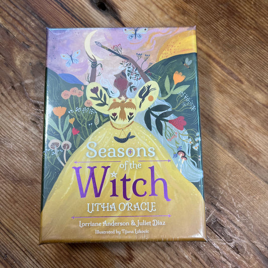 Oracle Card deck  titled 'Seasons of the Witch Litha Oracle' on a wooden surface