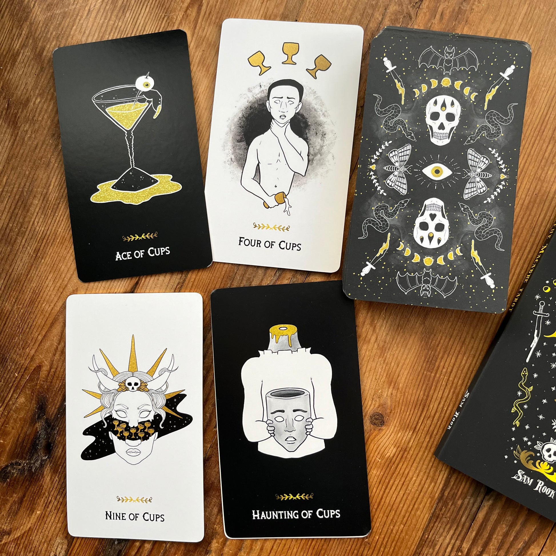 Collection of tarot cards with artistic designs on a wooden surface