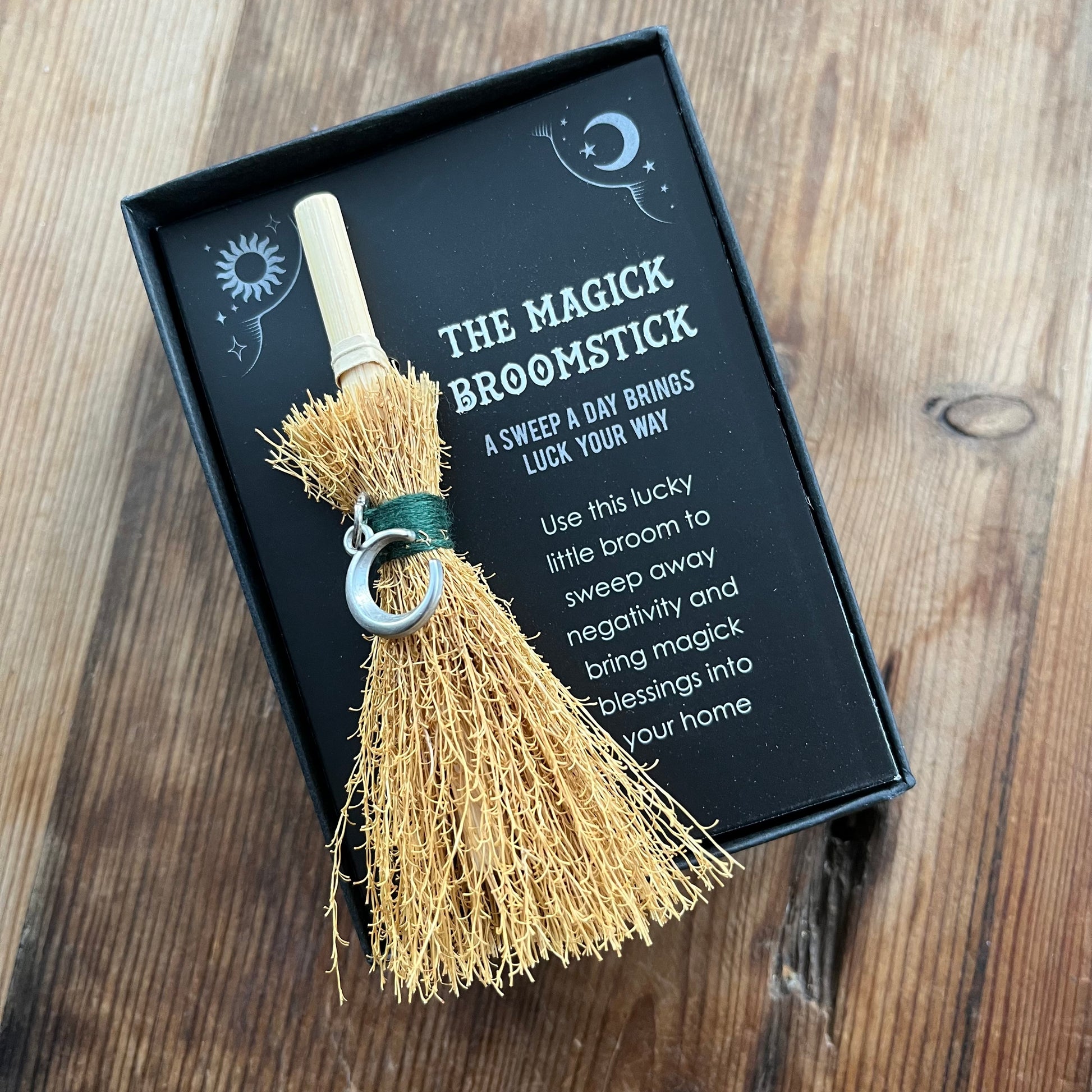 Magick broomstick with black box on wooden surface