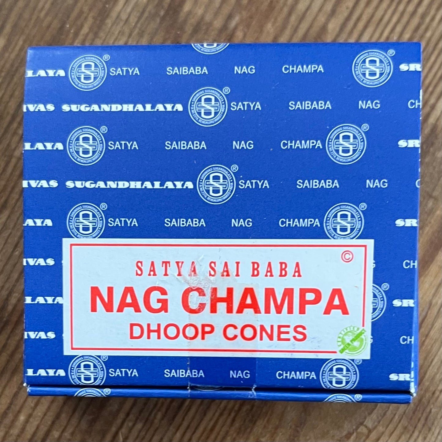 Box of Nag Champa Dhoop incense cones by Satya on wooden surface 