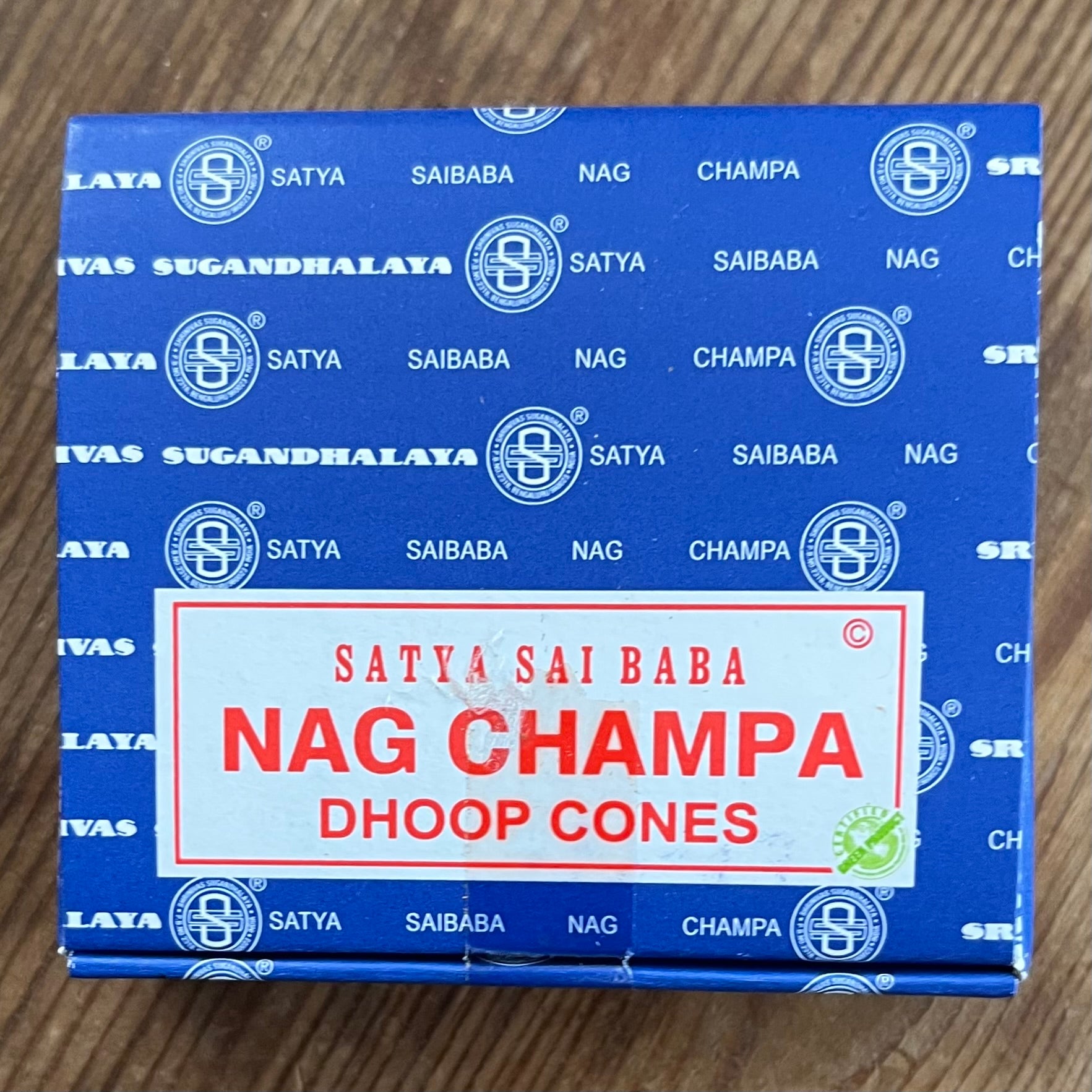 Box of Nag Champa Dhoop incense cones by Satya on wooden surface 