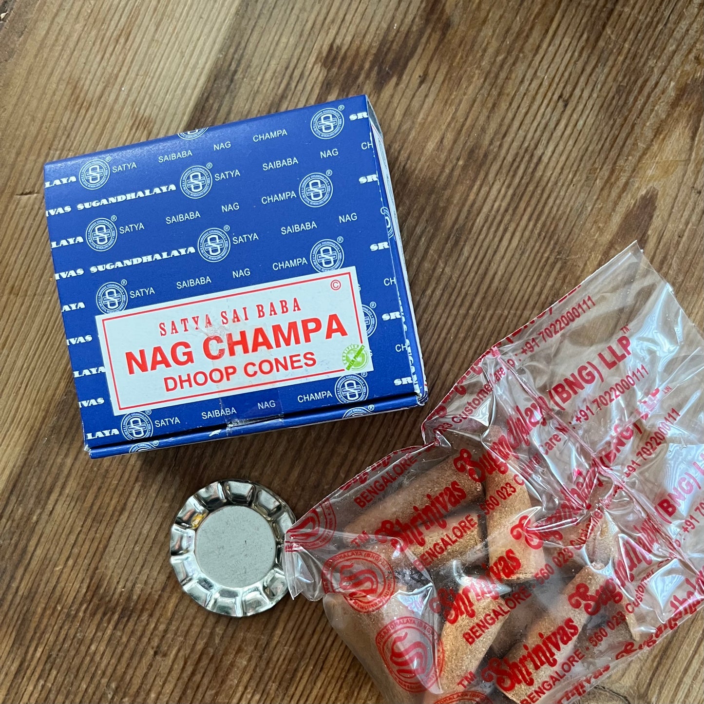 Box of Nag Champa Dhoop incense cones by Satya on wooden surface 