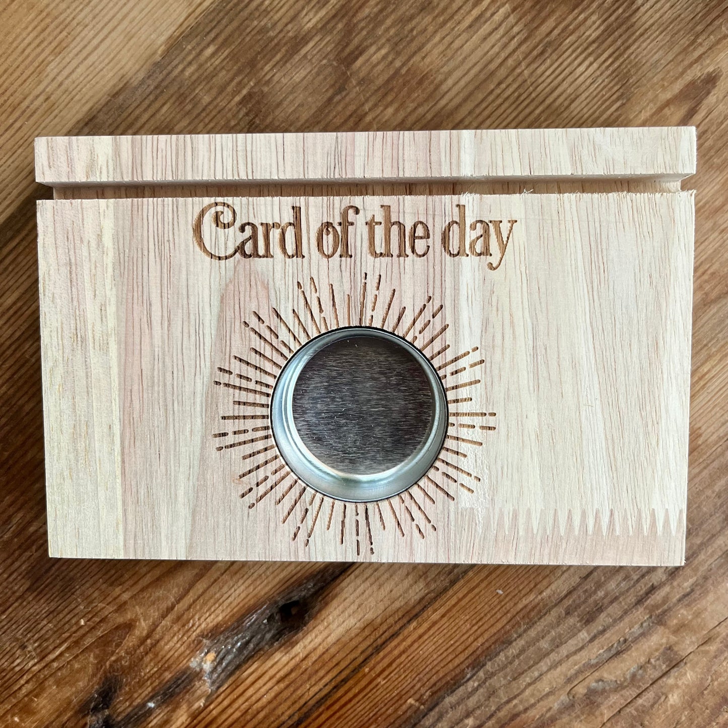 Natural wood Tarot card stand. with words Card of the day etched in the wood.A slot to place Tarot card and hold it upright. Space  will hold 2 cards. A circular cut out filled with a metal tealight holder. 