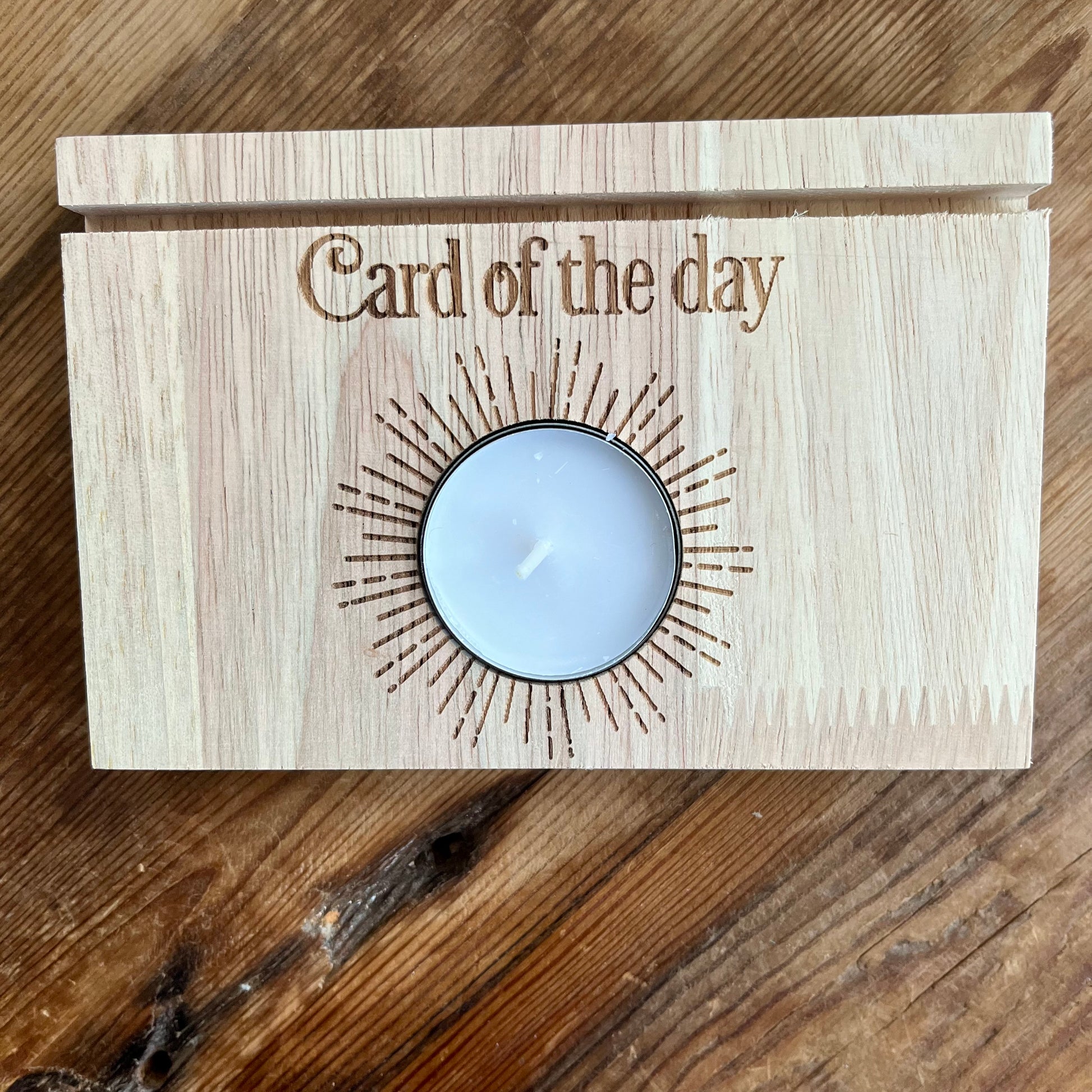 Natural wood Tarot card stand. with words Card of the day etched in the wood.A slot to place Tarot card and hold it upright. Space  will hold 2 cards. A white tealight candle sits within a circular cut out space 