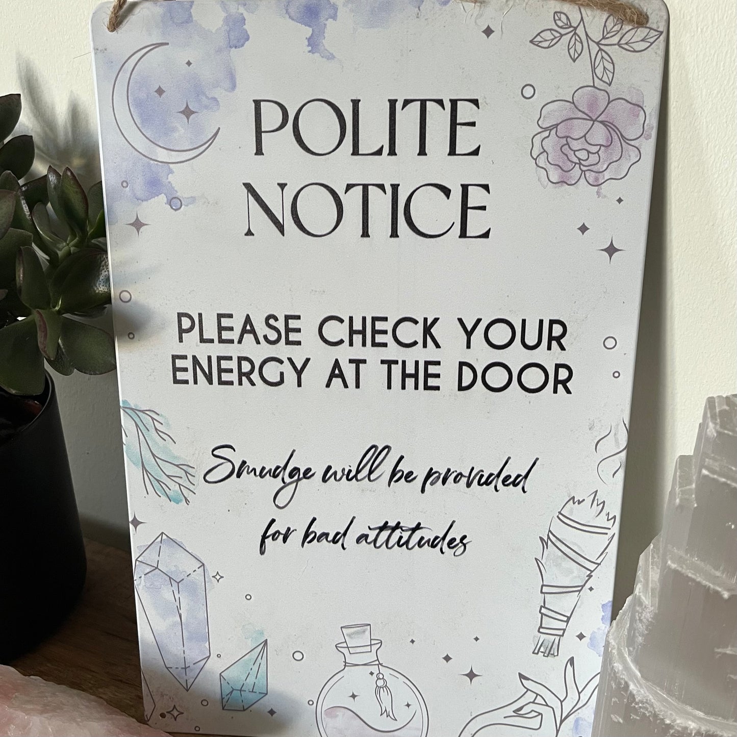 Decorative sign with humorous message about energy checks and smudging.