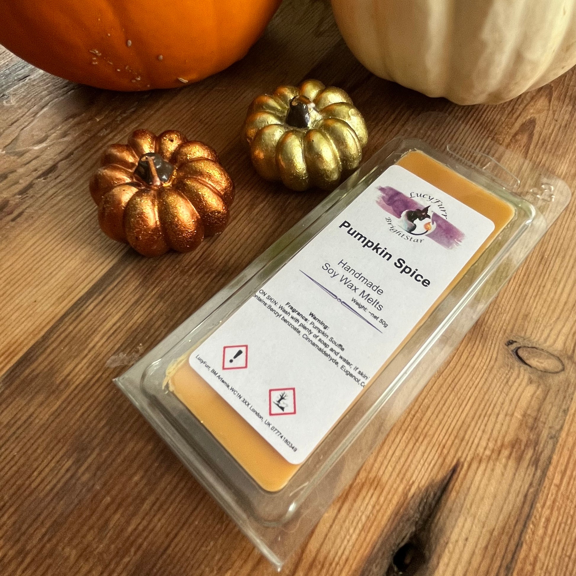 Pack of Pumpkin Spice soy wax melts on a wooden surface with decorative pumpkins.