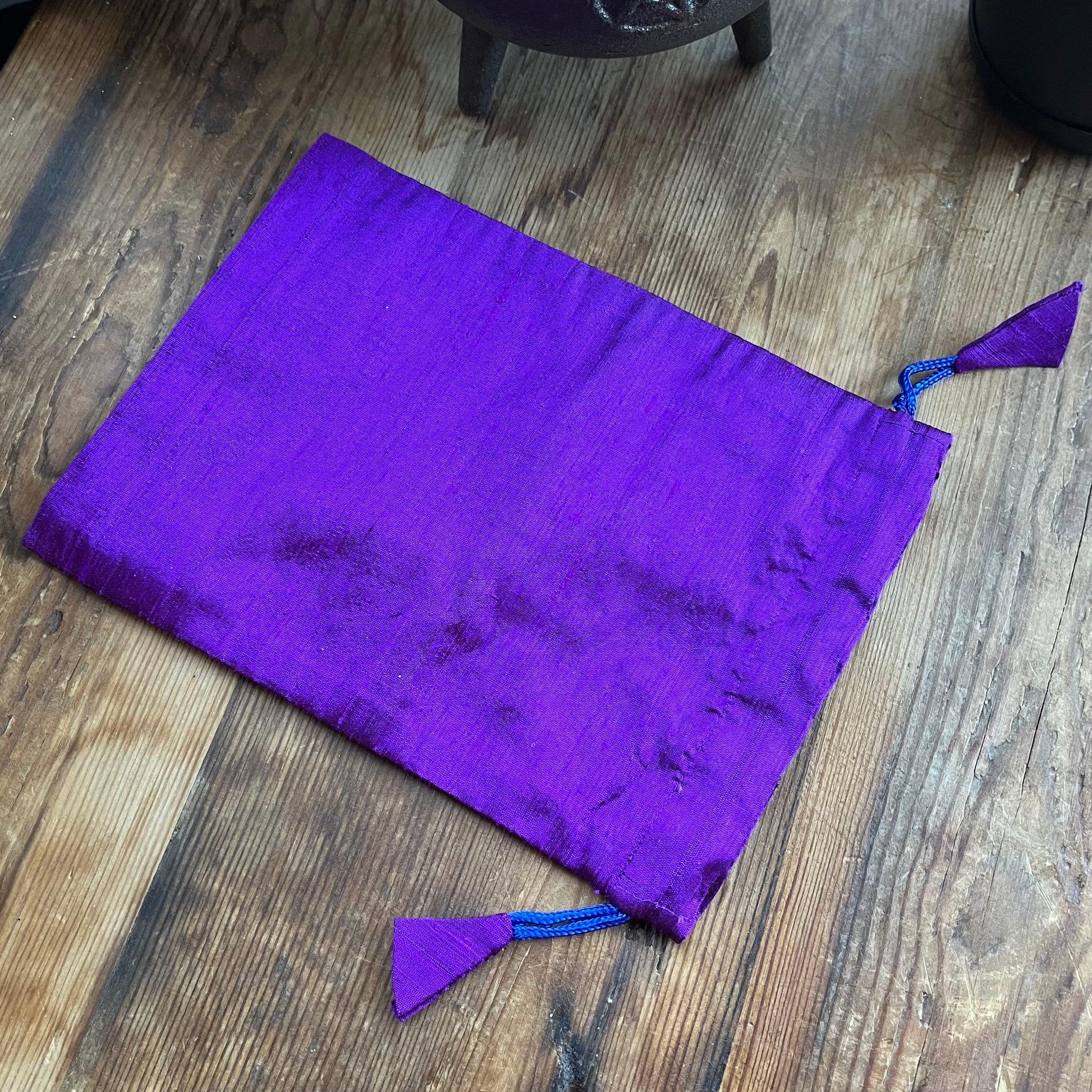 Purple drawstring bag on a wooden floor