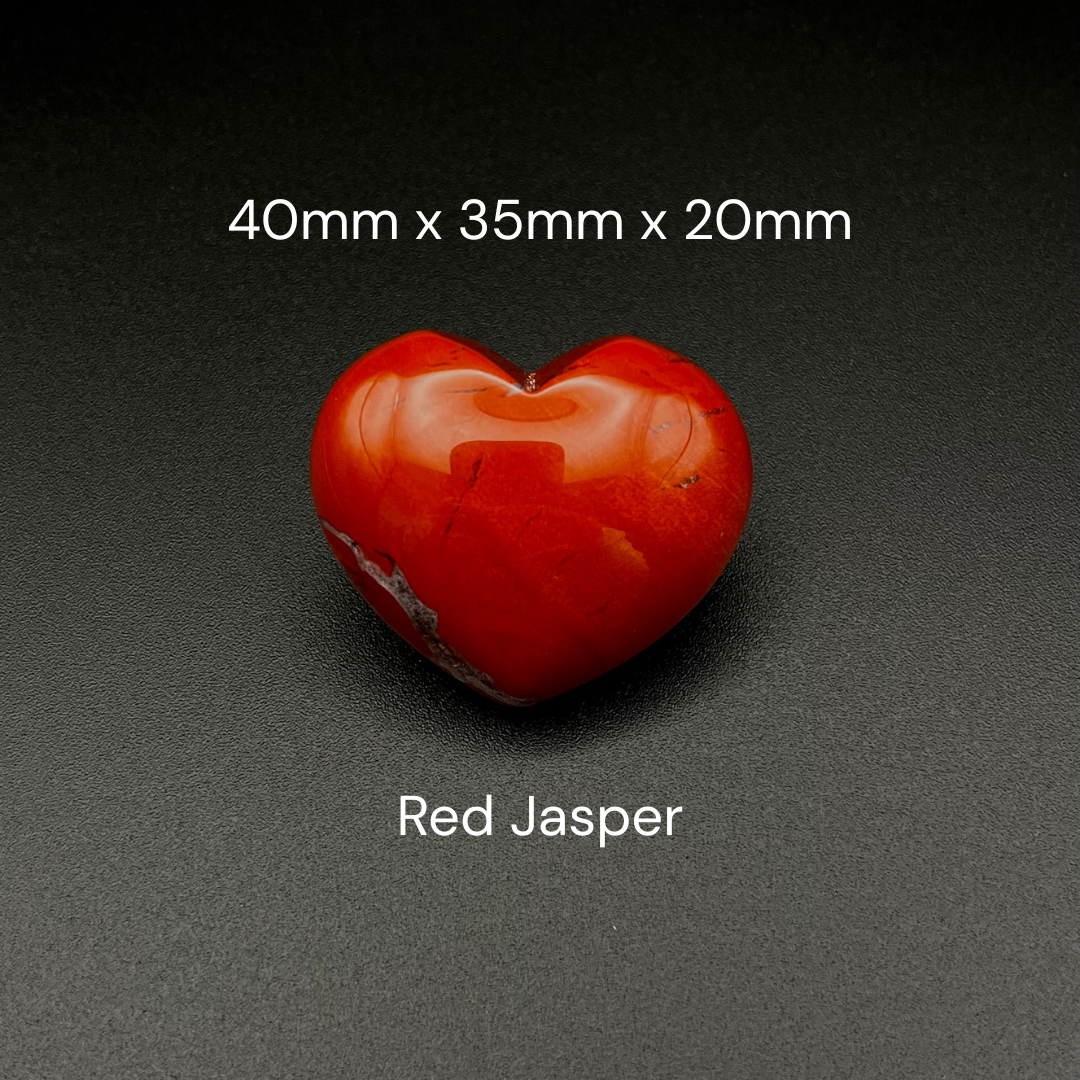 A polished red heart-shaped red jasper stone centered on a dark textured background, with white text reading '40mm x 35mm x 20mm' above and 'Red Jasper' below.