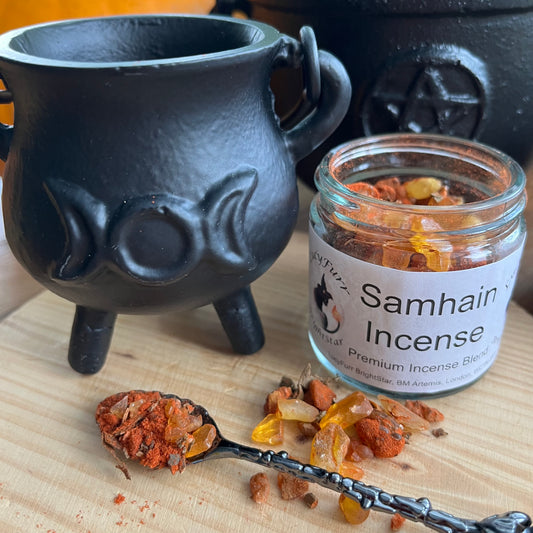 Black cauldron with Samhain incense on a wooden surface