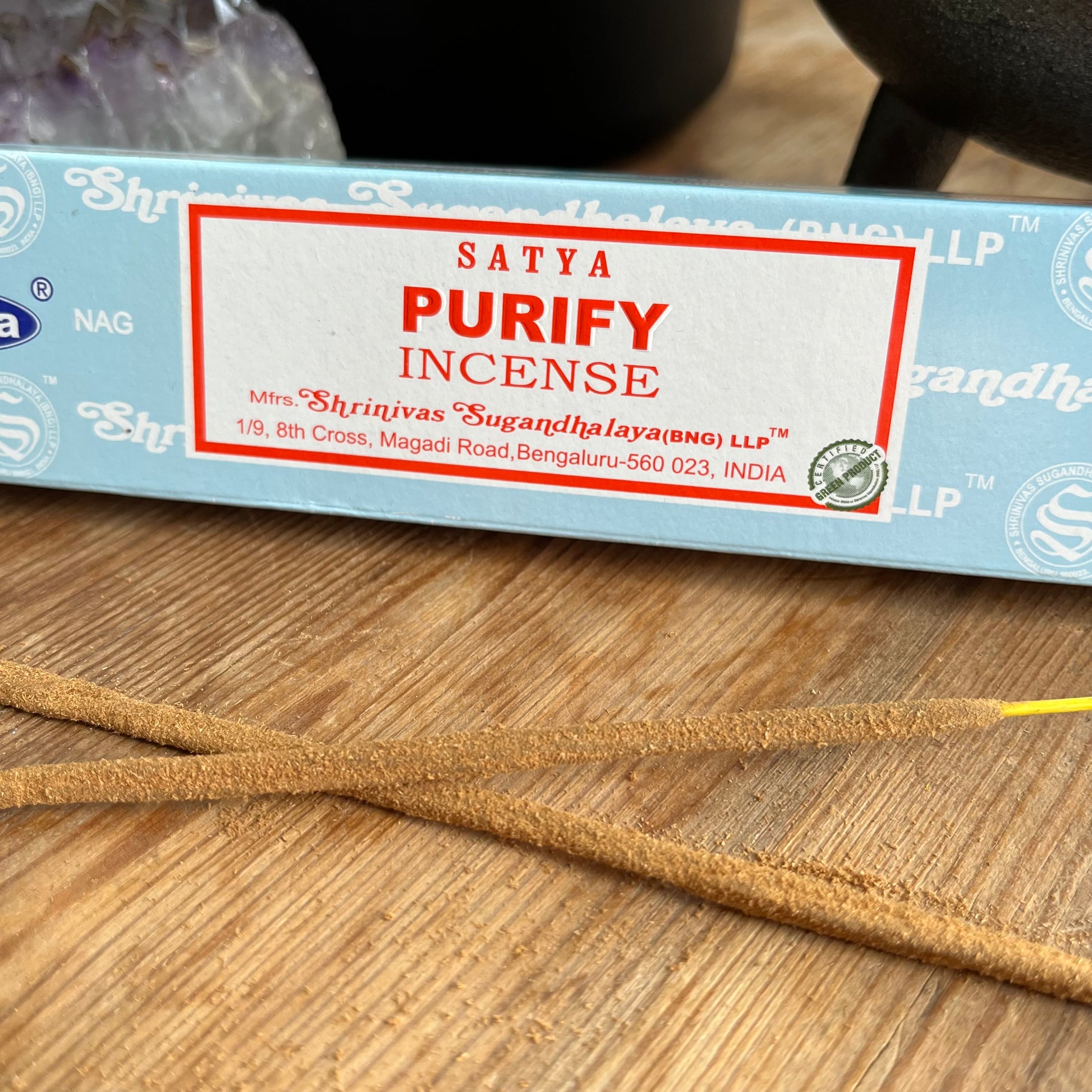 A box of Satya Purify incense placed on a wooden surface, with the brand name and product description visible.