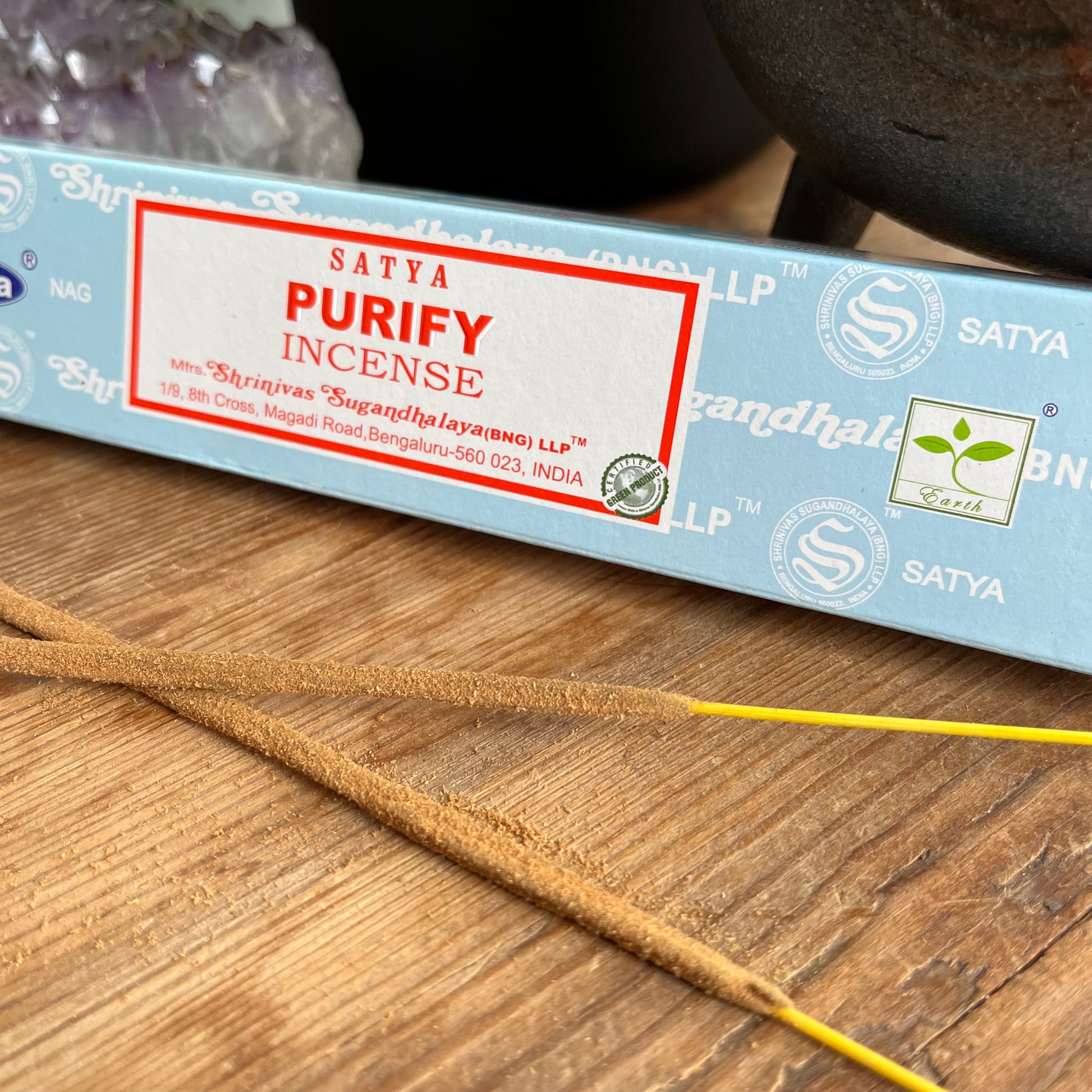 A box of Satya Purify incense placed on a wooden surface, with the brand name and product description visible.