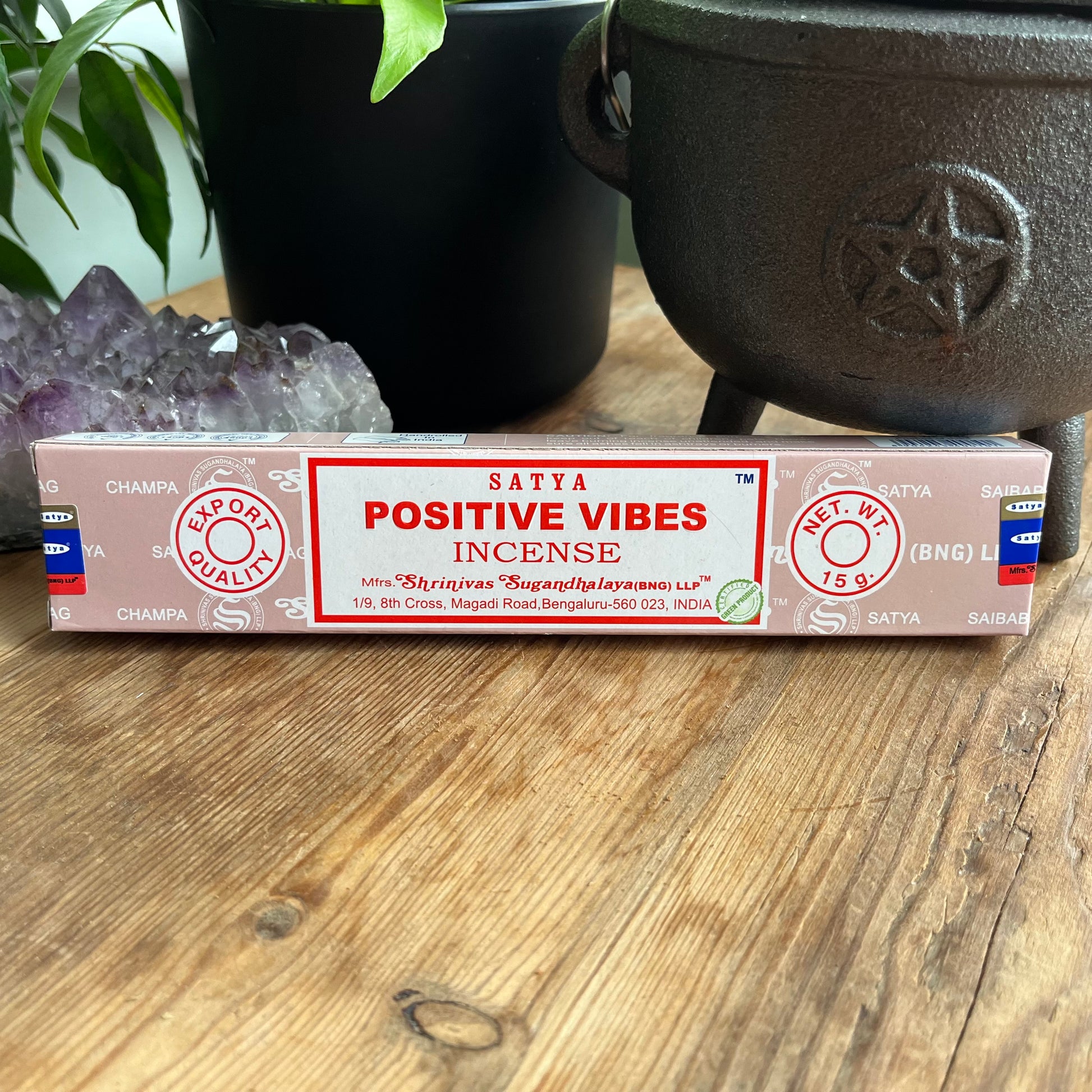 Box of Satya positive vibes incense on a wooden table with a cauldron and crystals