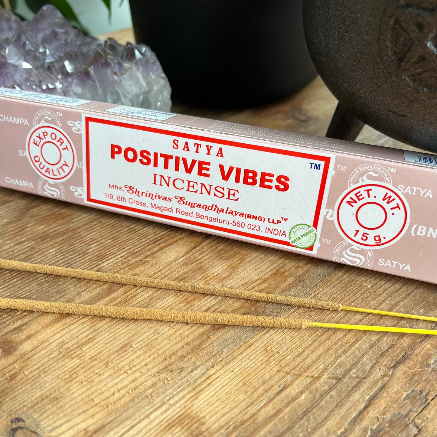 Box of satya positive vies incense with some loose incense sticks on a wooden table 