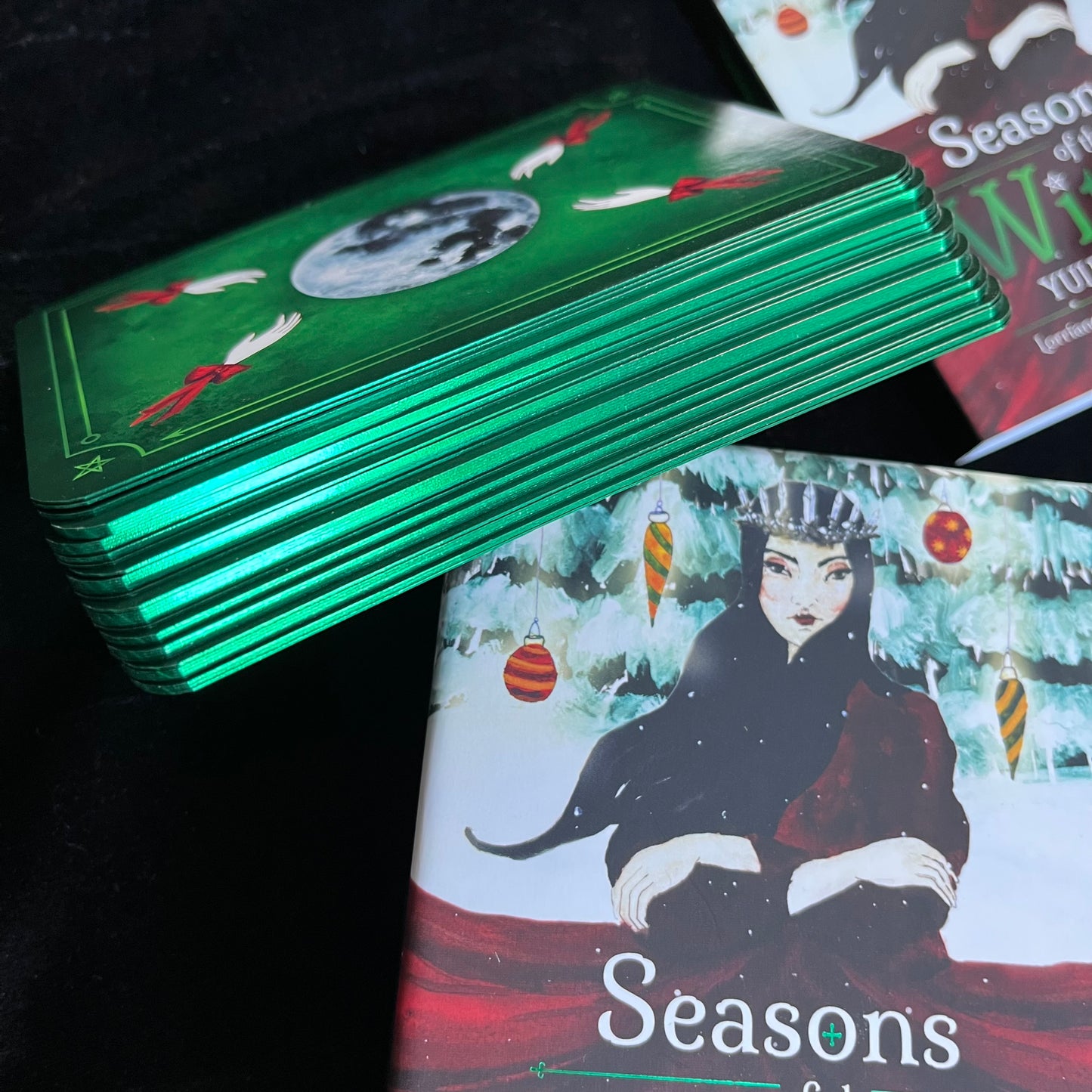 Stack of tarot cards with a green metallic sheen on a black background