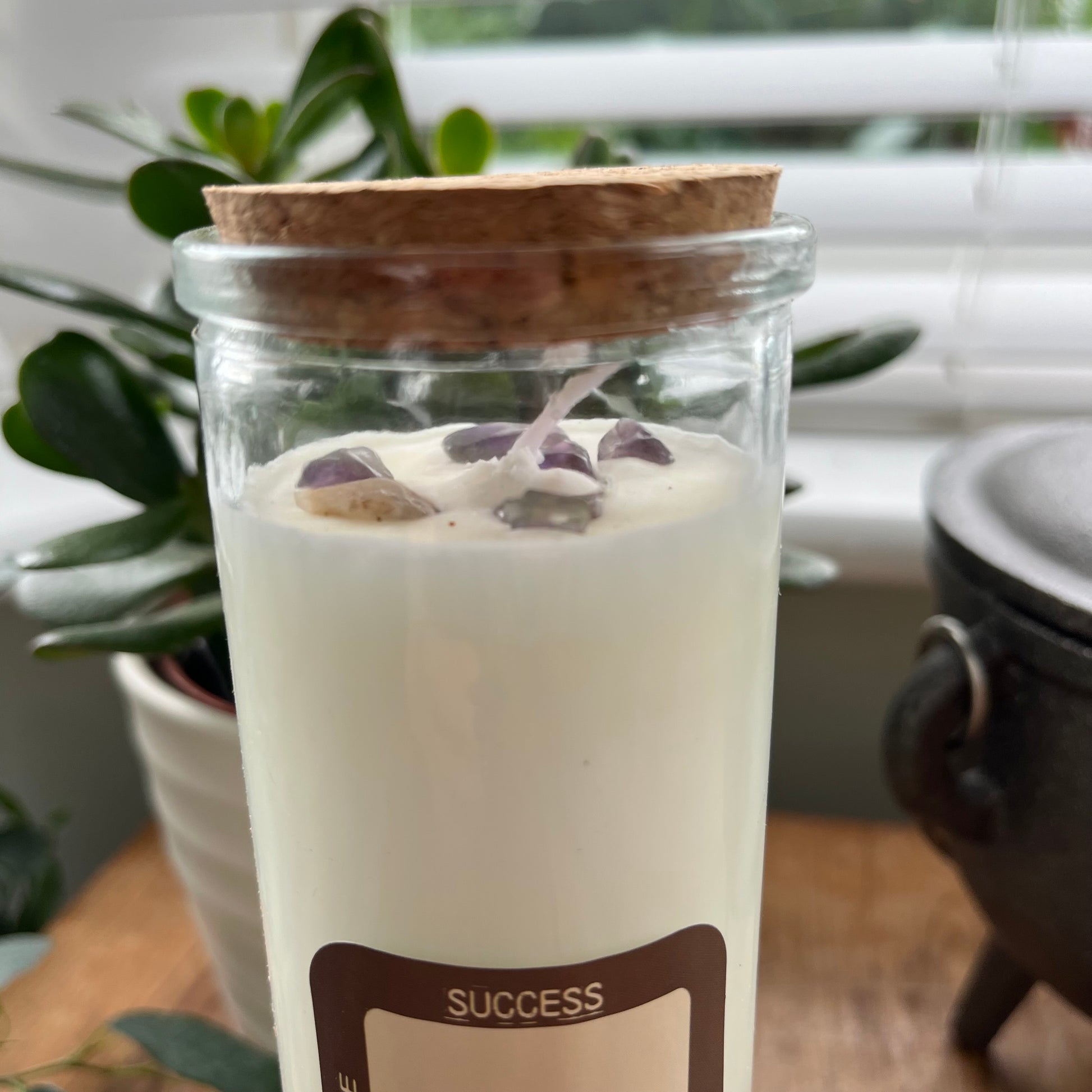 An over head view of the Success magic candle showing a closer up image of the embedded amethyst crystals 