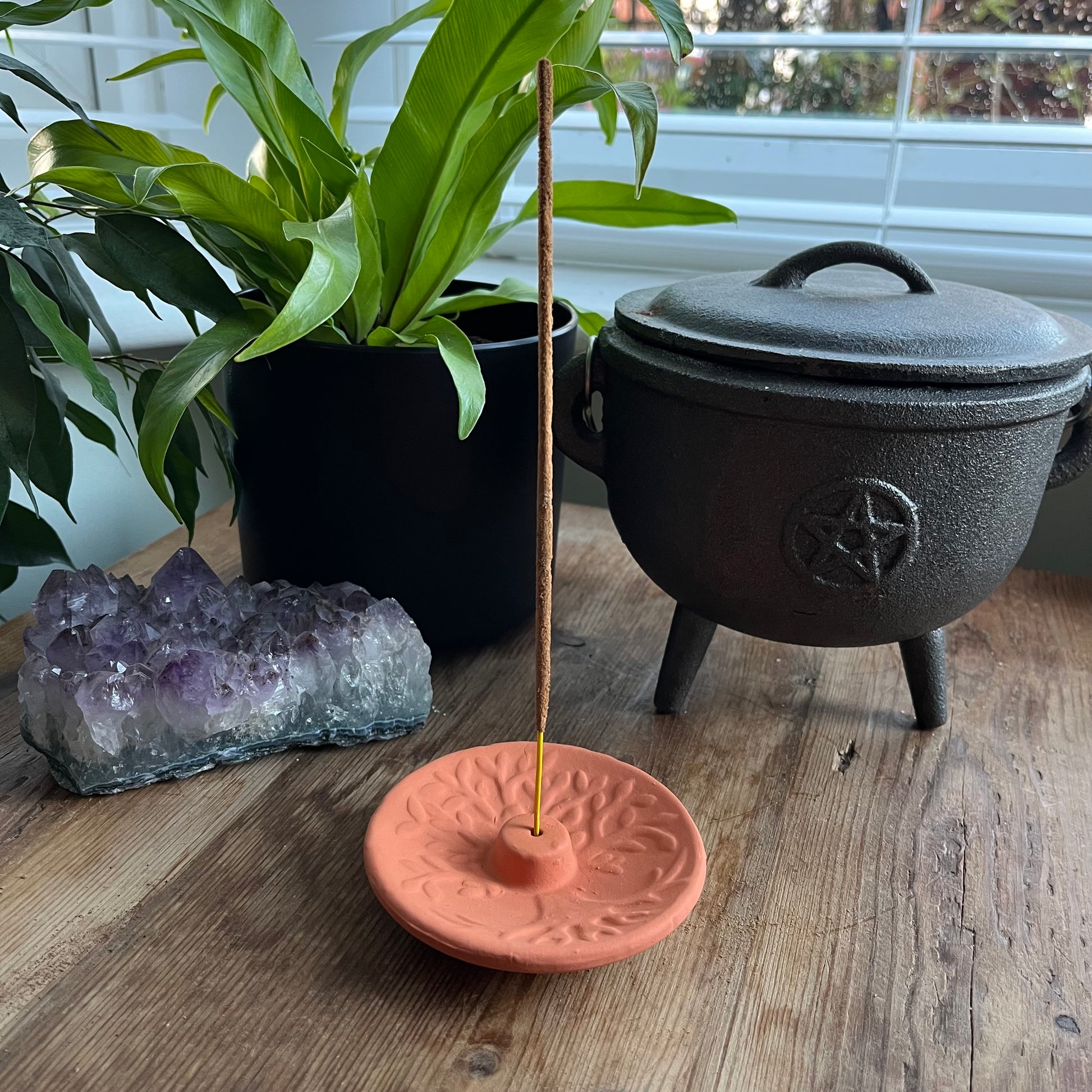 Terracotta Incense Plate with a Tree of Life design n the surface and the hole for the incense stick in the centre 