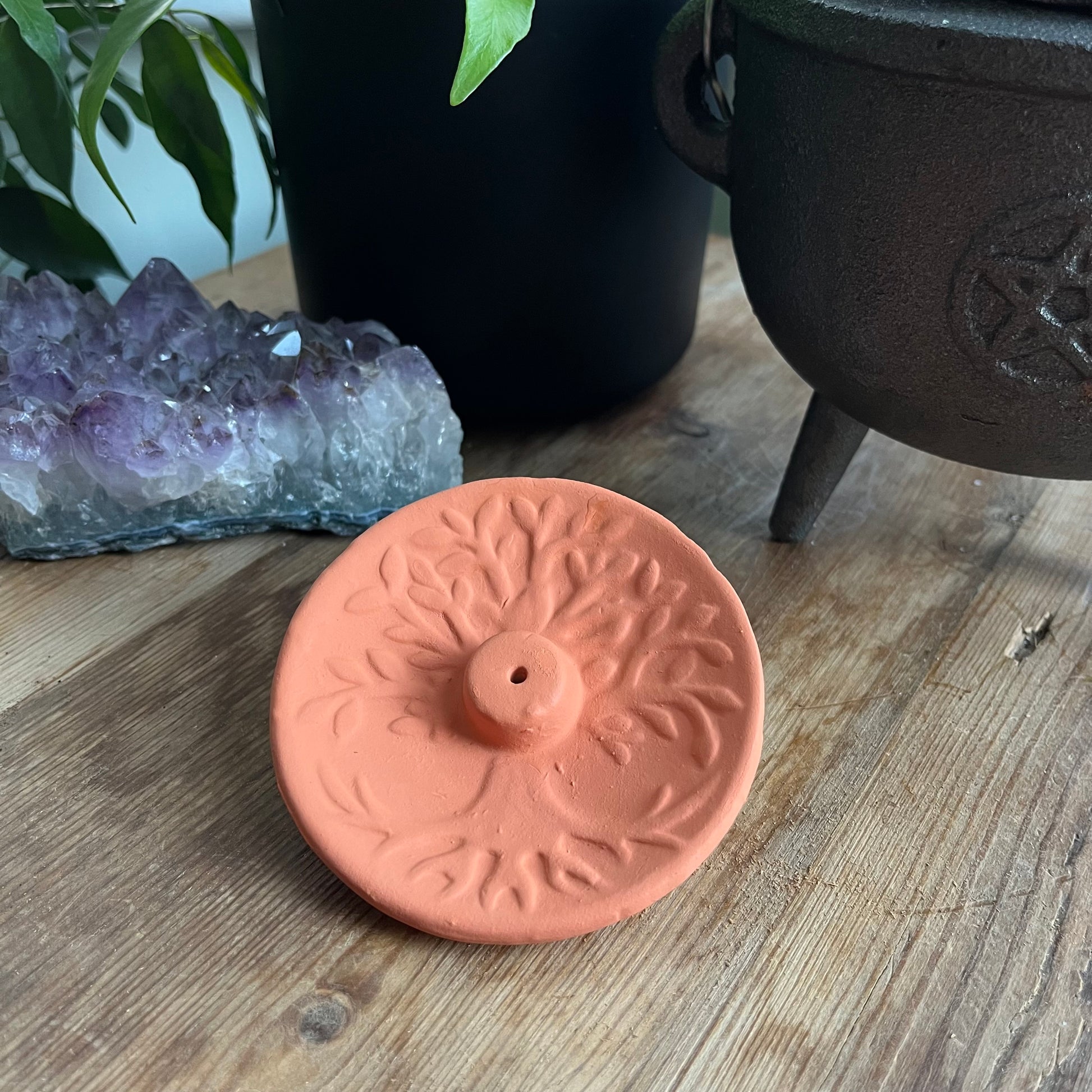 Terracotta Incense Plate with a Tree of Life design n the surface and the hole for the incense stick in the centre 