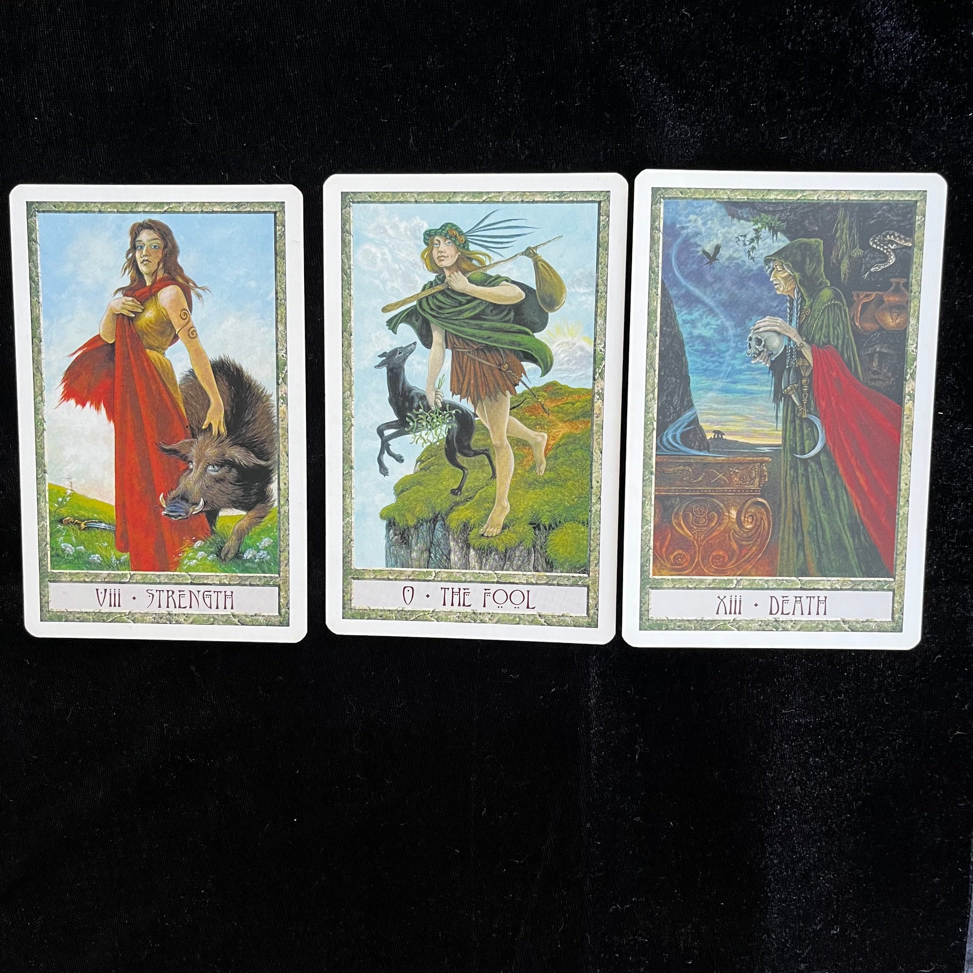 Three tarot cards labeled 'Strength', 'The Fool', and 'Death' on a black background.